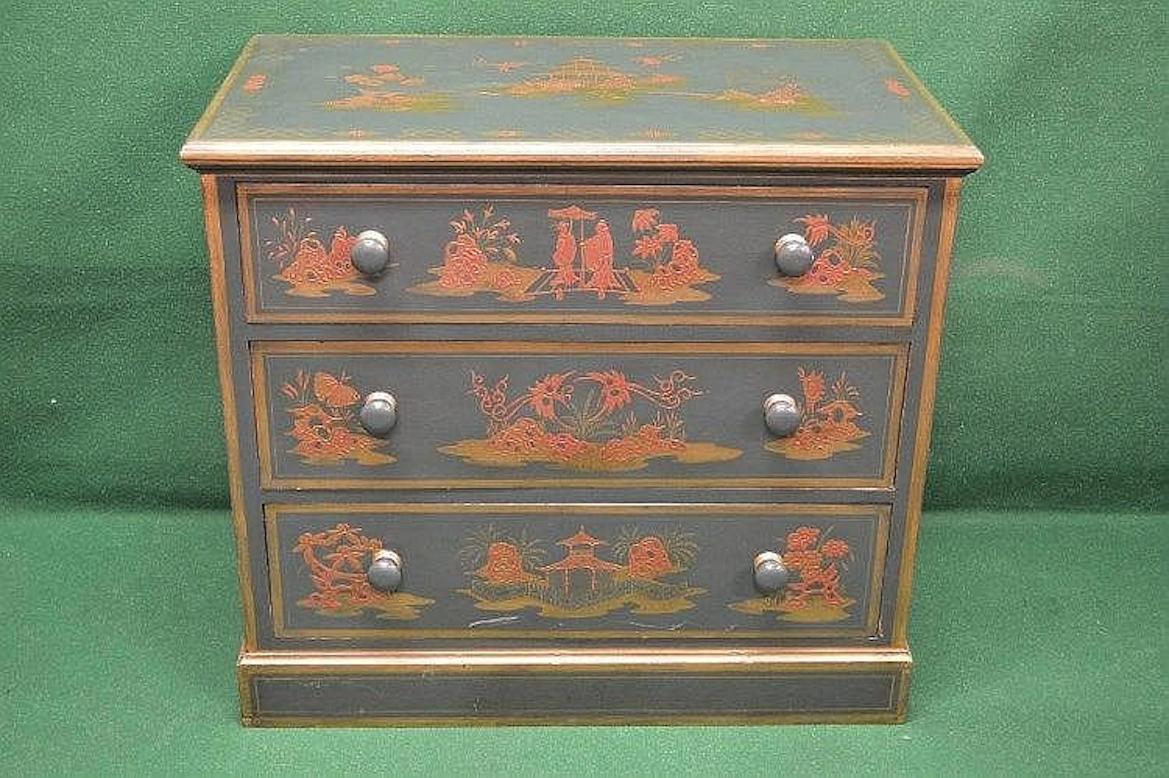 A green painted chest of drawers decorated with scenes of figures