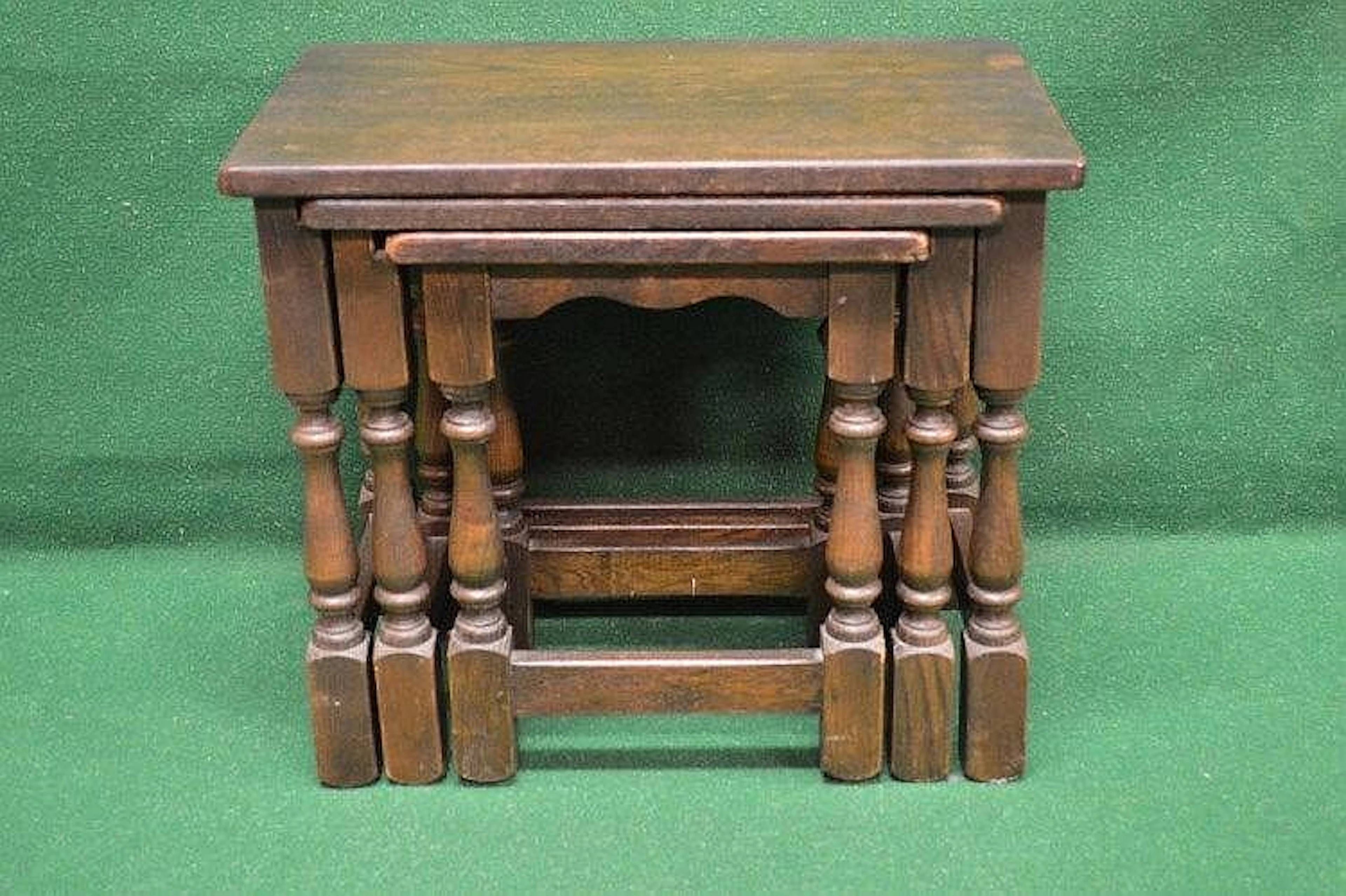 A nest of three oak occasional tables having moulded tops...
