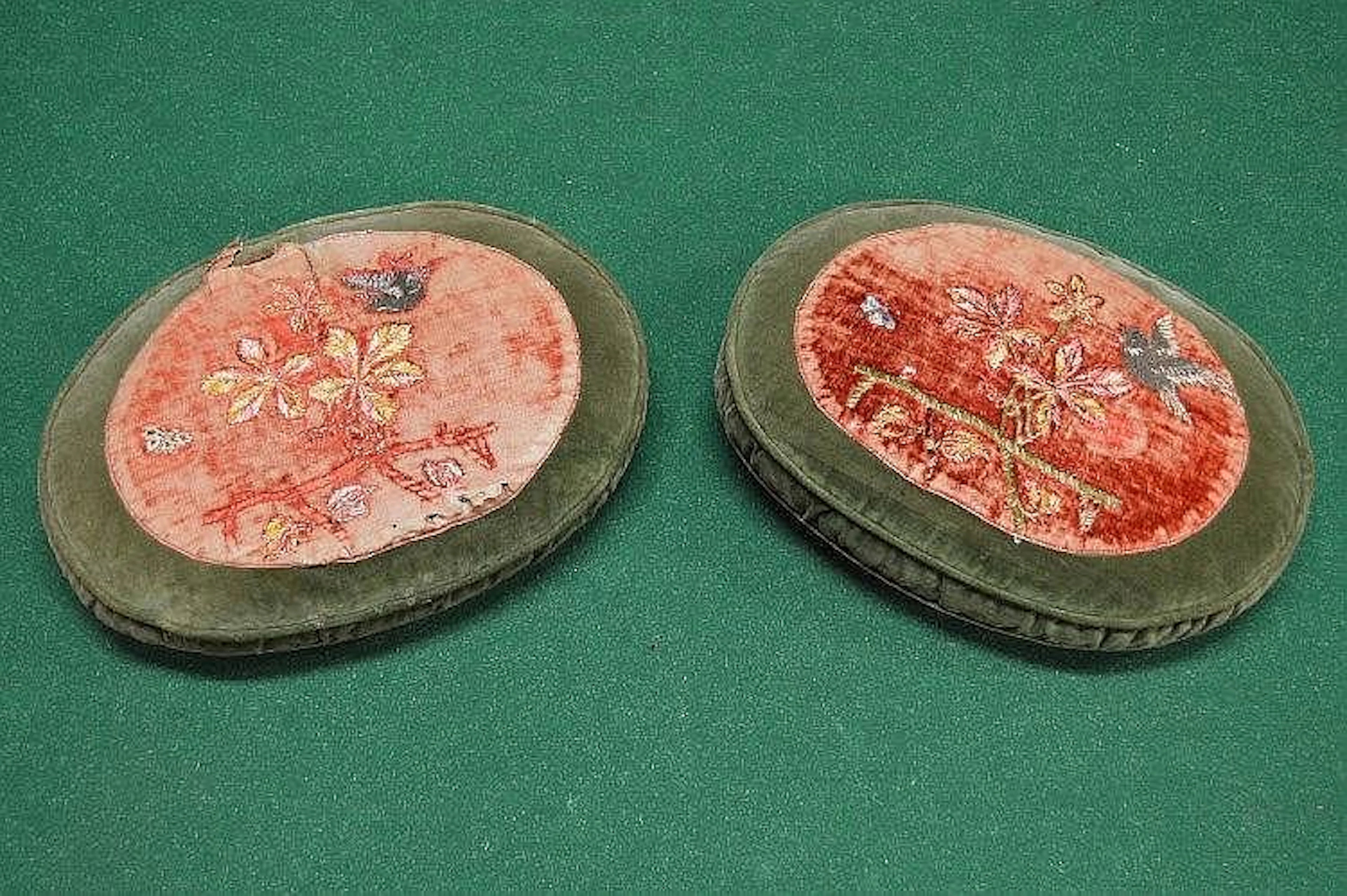 Two vintage scatter cushions of oval form with needlework decoration of birds