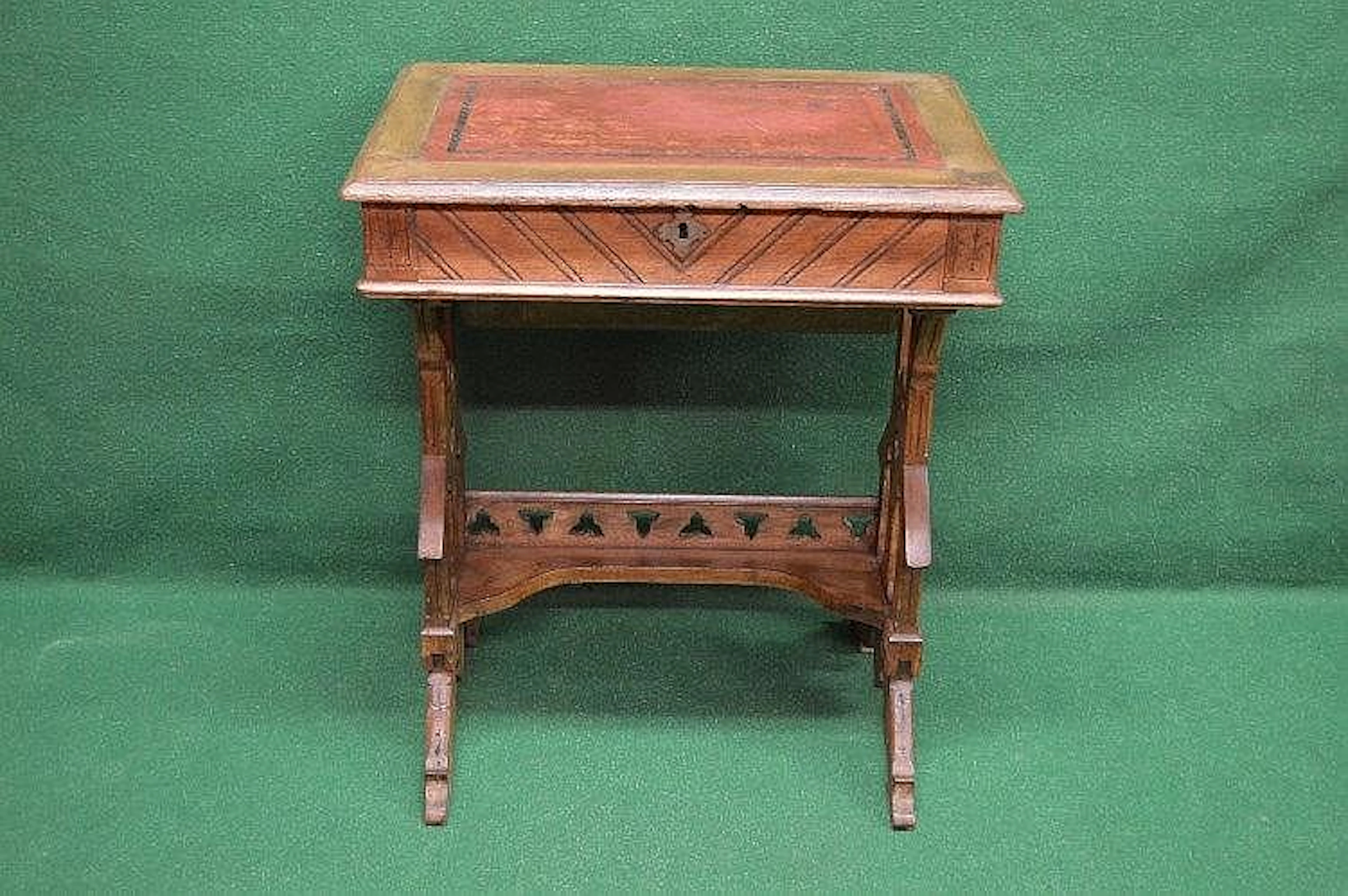 An oak Arts & Crafts work table having red leather insert...
