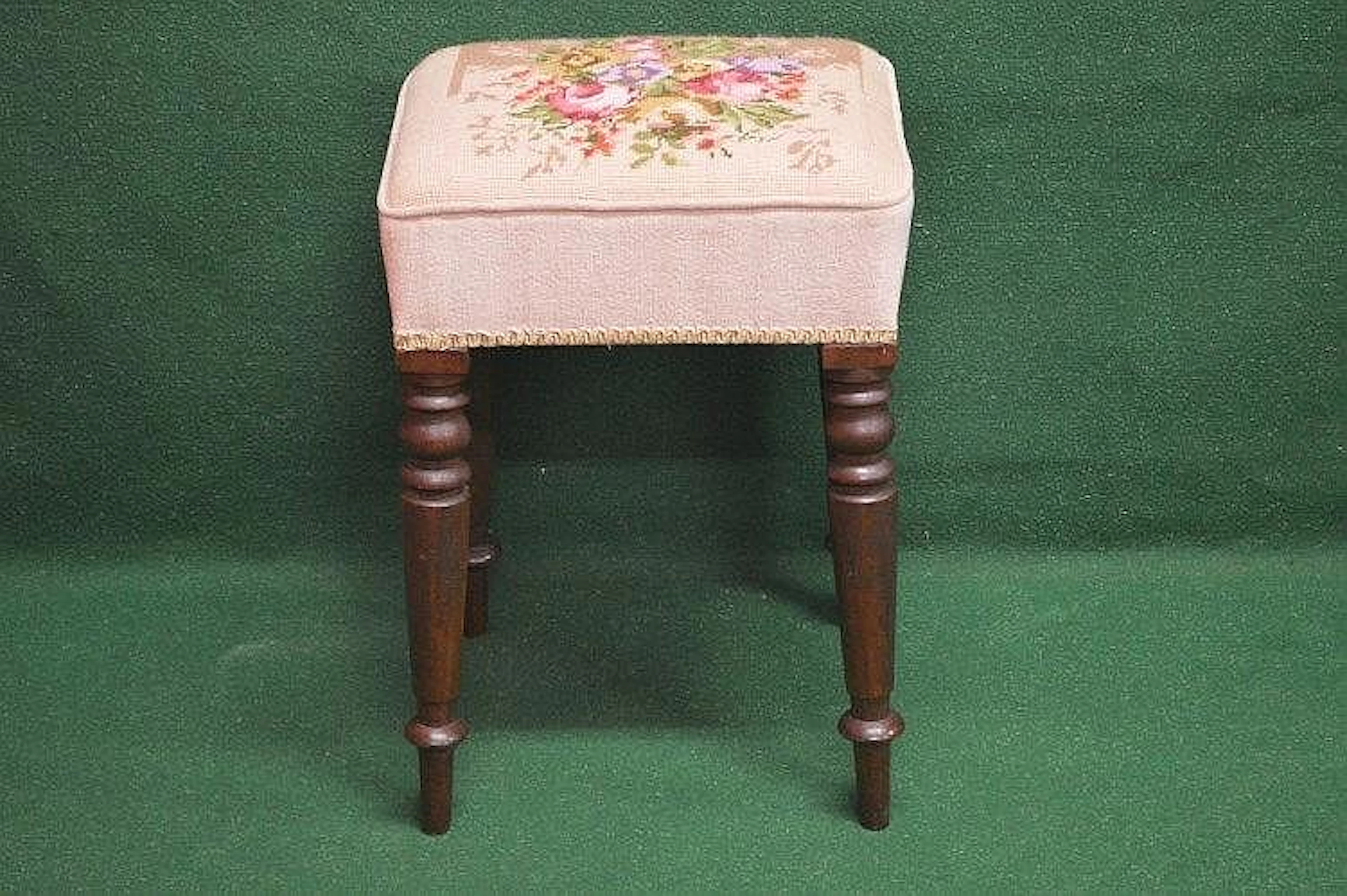 A mahogany framed dressing stool having floral needlework...