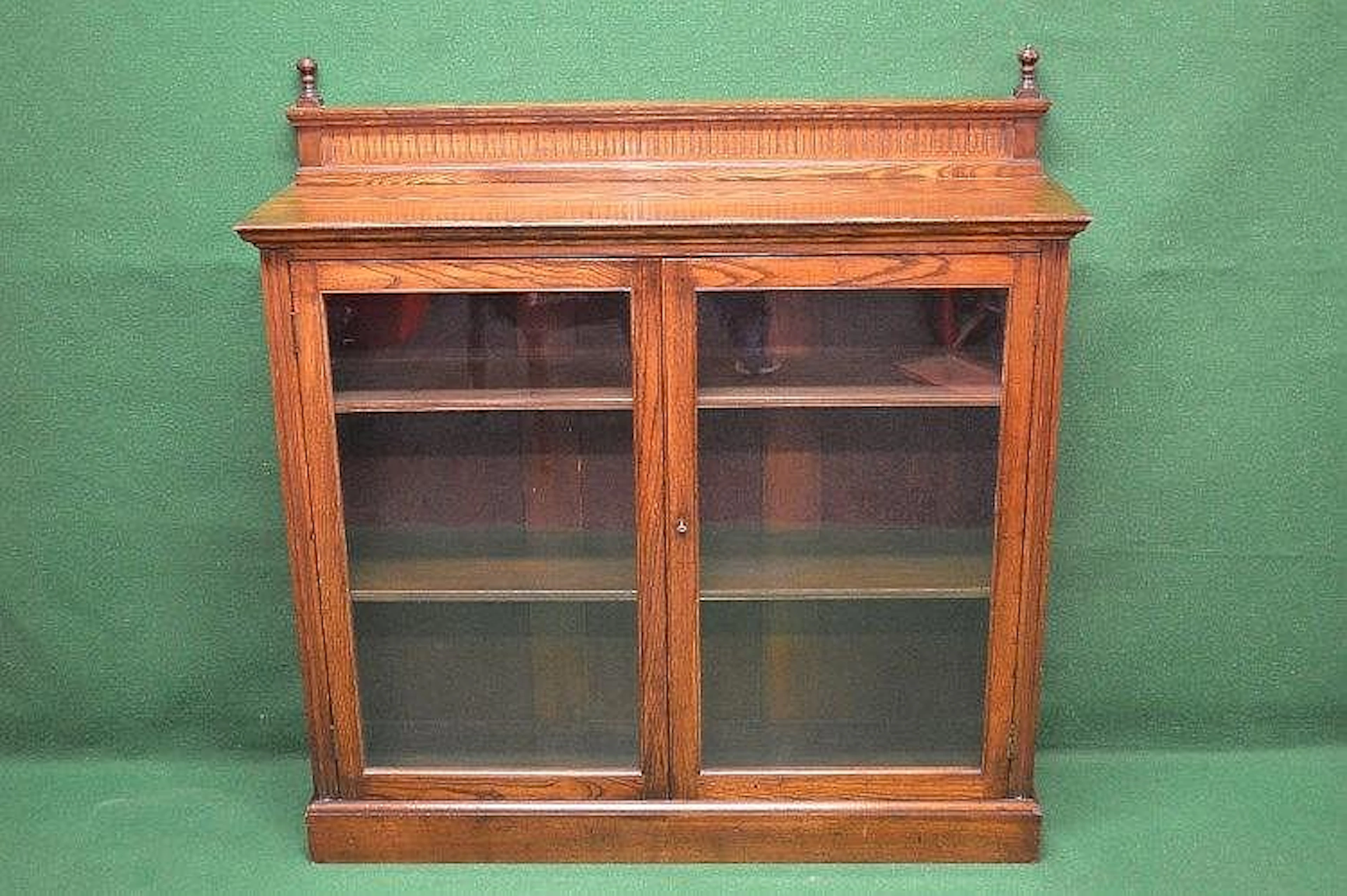 Oak glazed bookcase with raised back