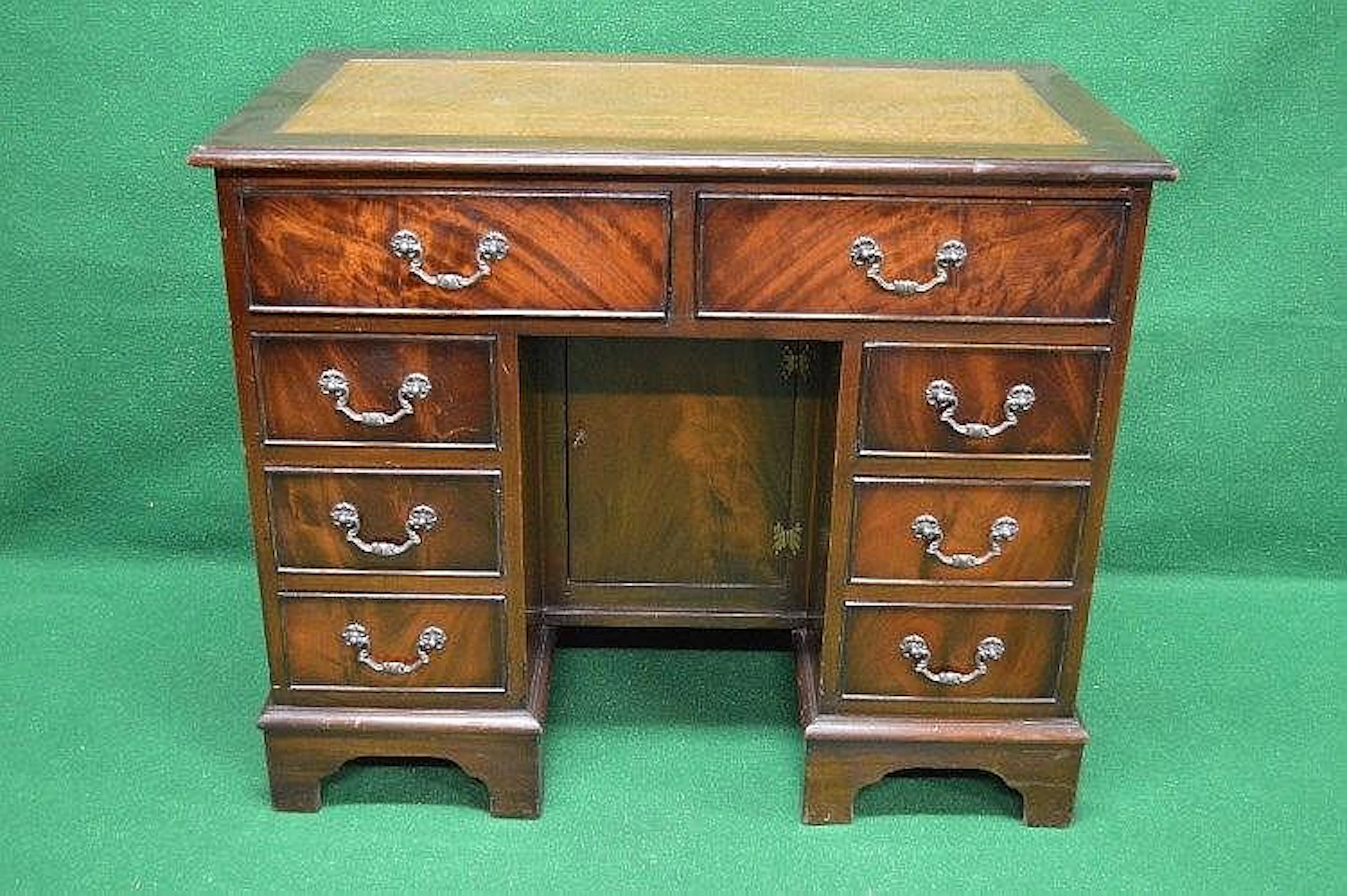 A 20th century mahogany desk having tan leather insert...