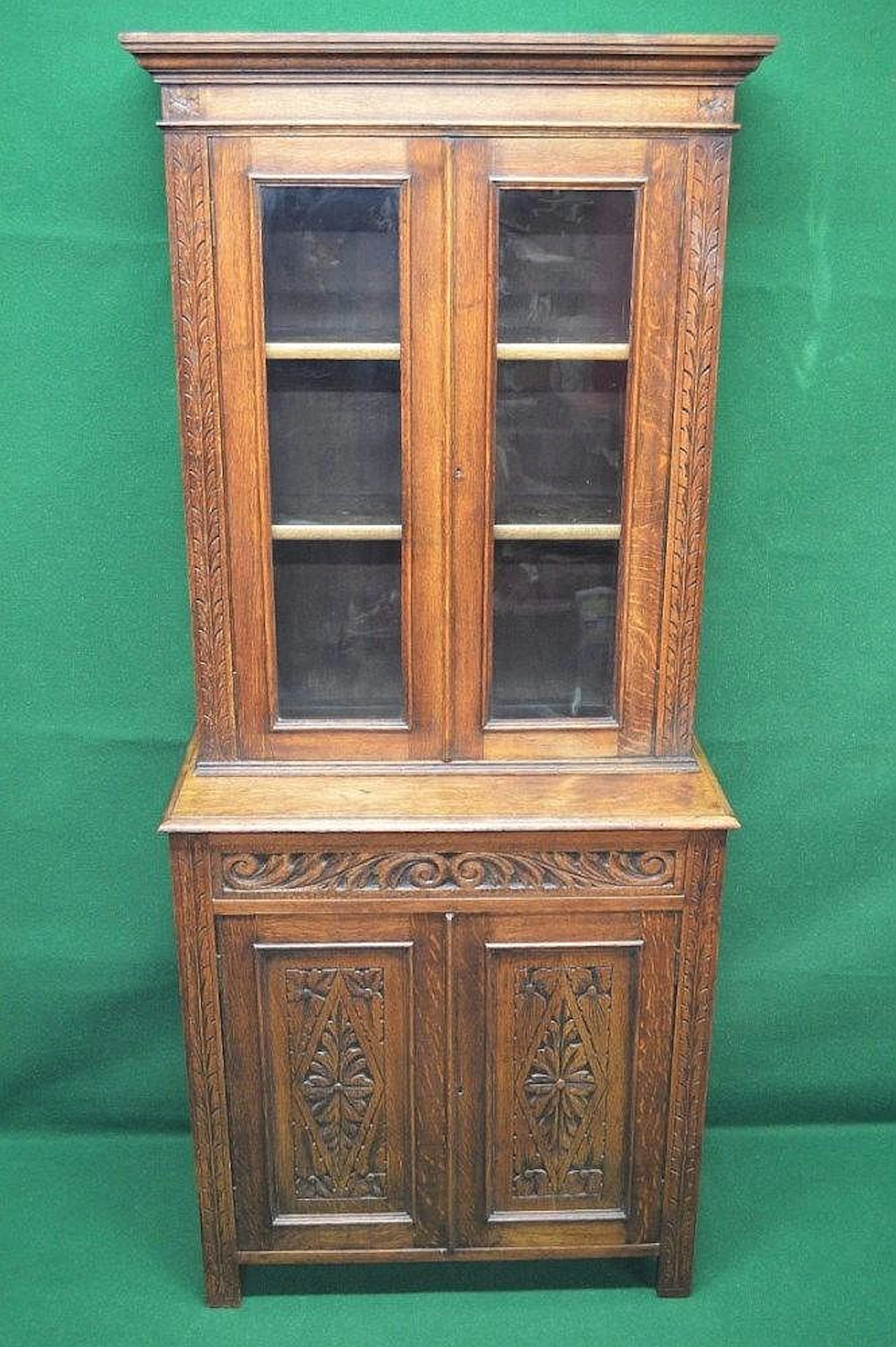 Oak glazed bookcase with carved decoration having glazed...