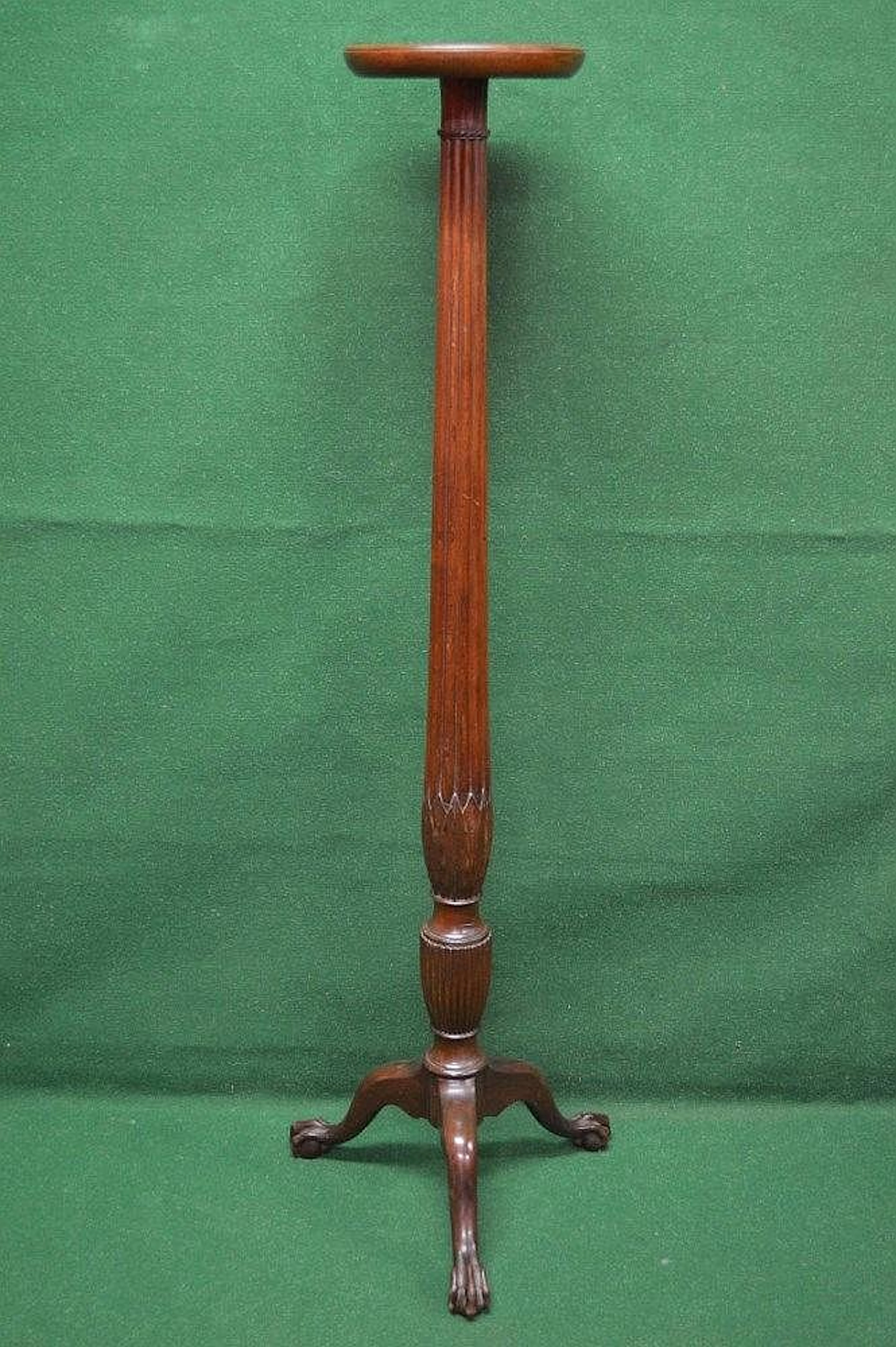 A mahogany torchere having circular top supported by...