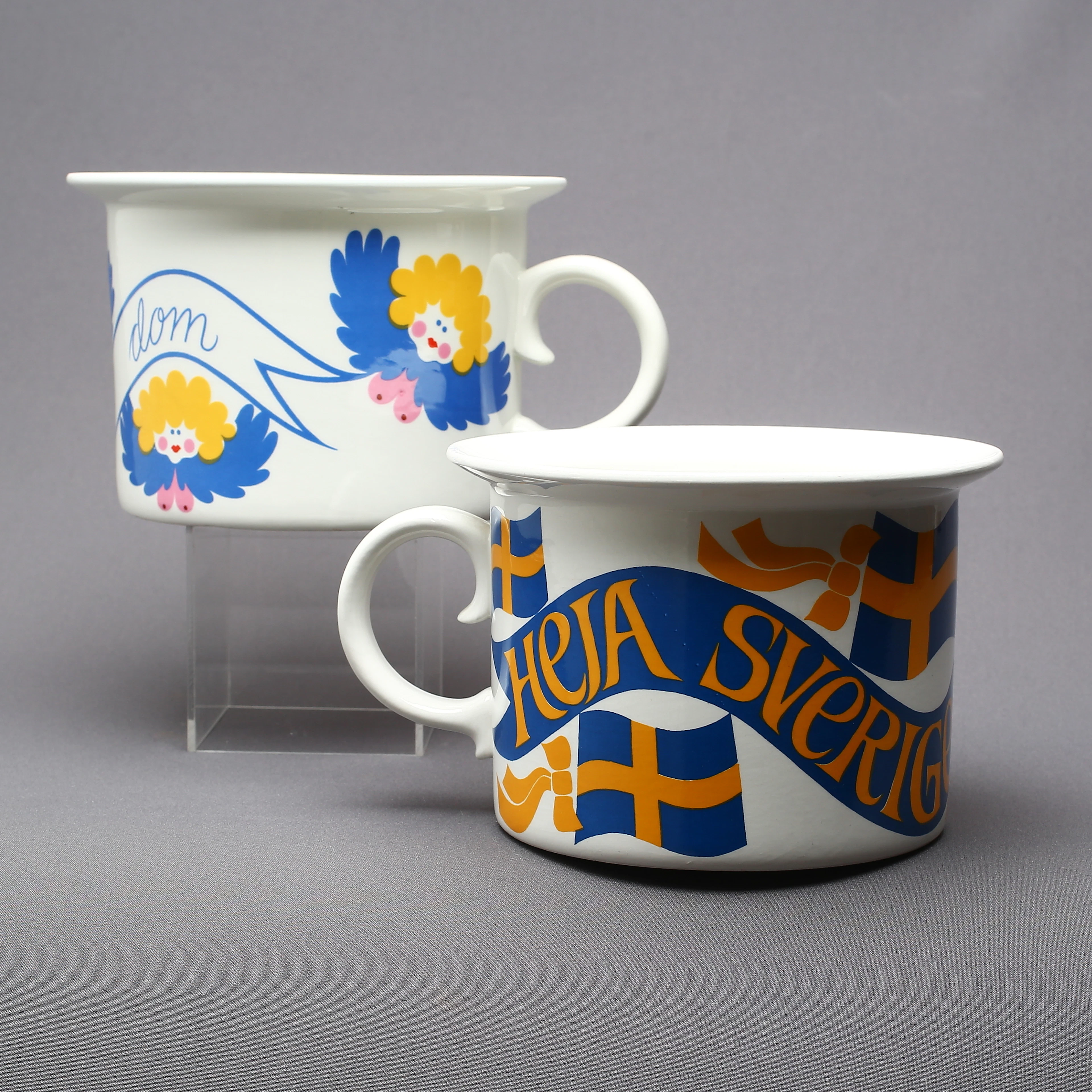 POTTOR, 2 st, porslin, "Heja Sverige Friskt Humör" samt "Änglar Finns Dom", Margareta Hennix, Gustavsberg.