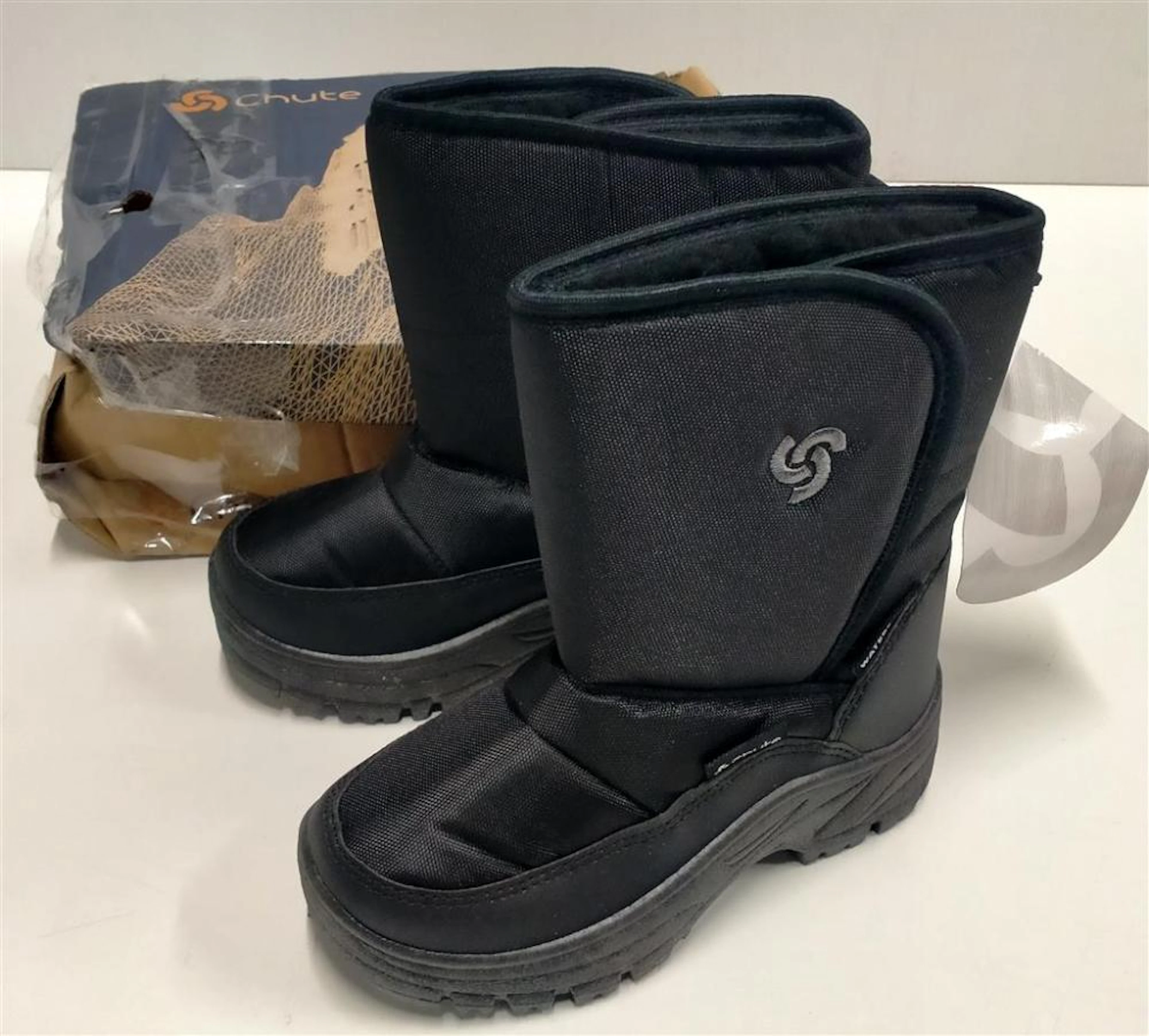 A pair of kids snow boots marked Chute Whistler size 27/28 in damaged box