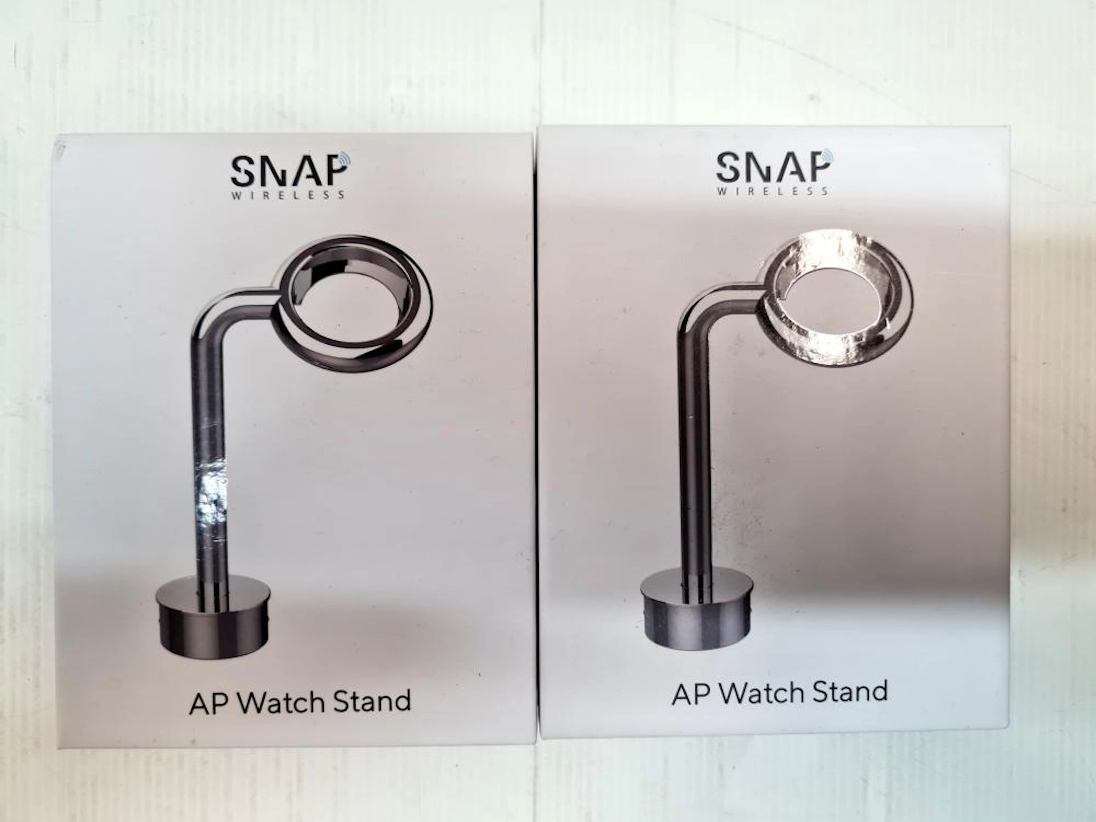 Two wireless watch stands marked SNAP