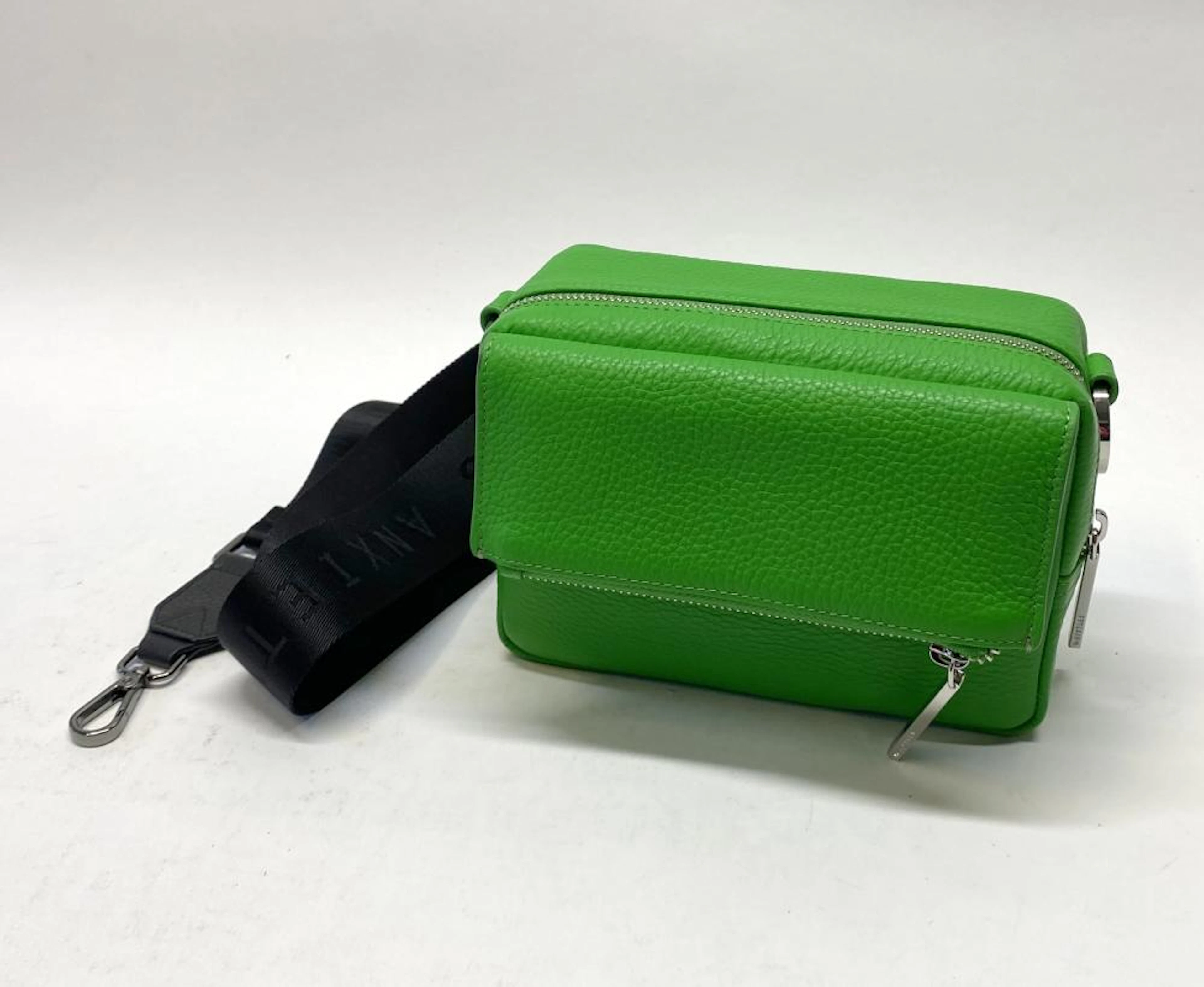 A green bag marked Whistler with strap marked Status Anxiety