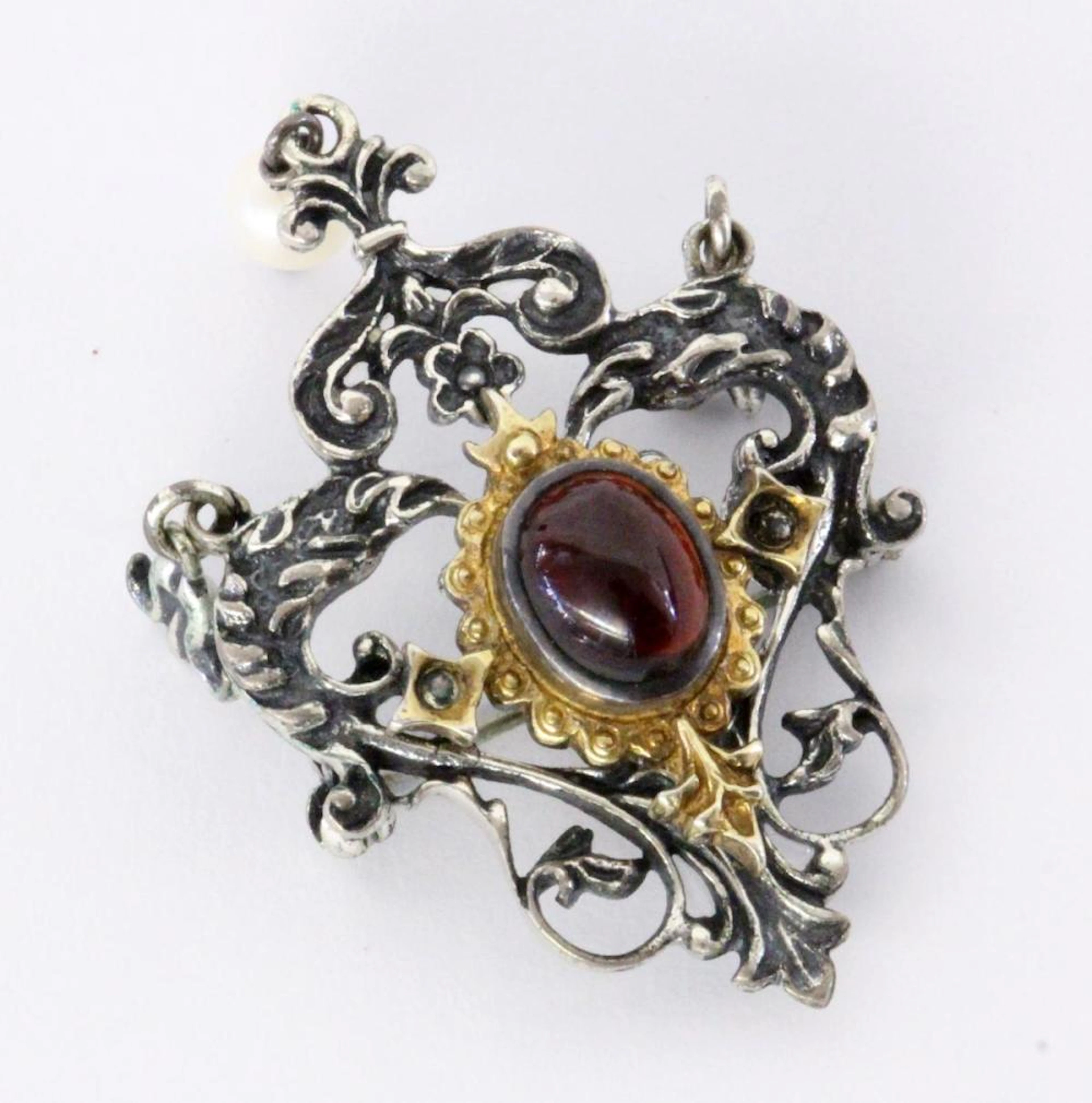 A COSTUME BROOCH Silver with a garnet cabochon