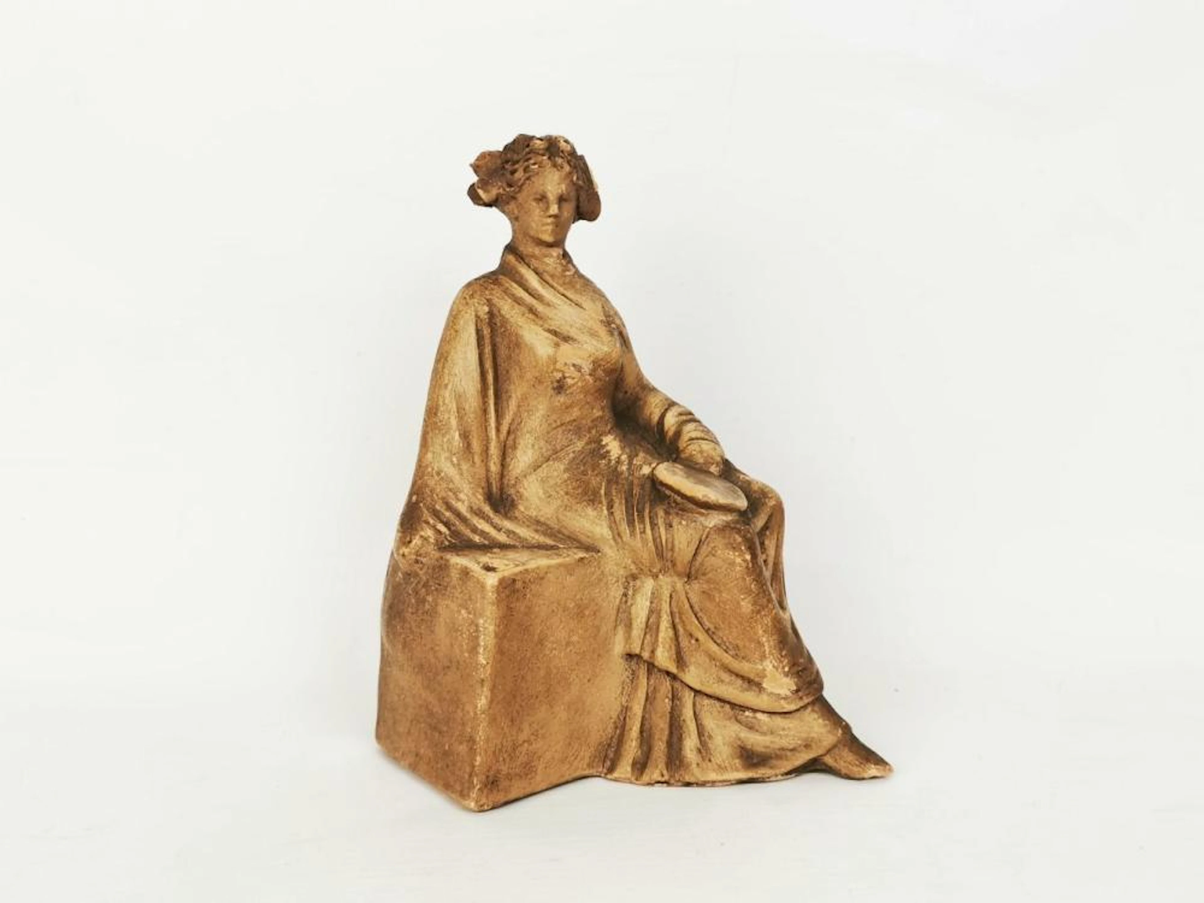 Statuette figurant une femme drapée assise. Ancien travail grec, style tana