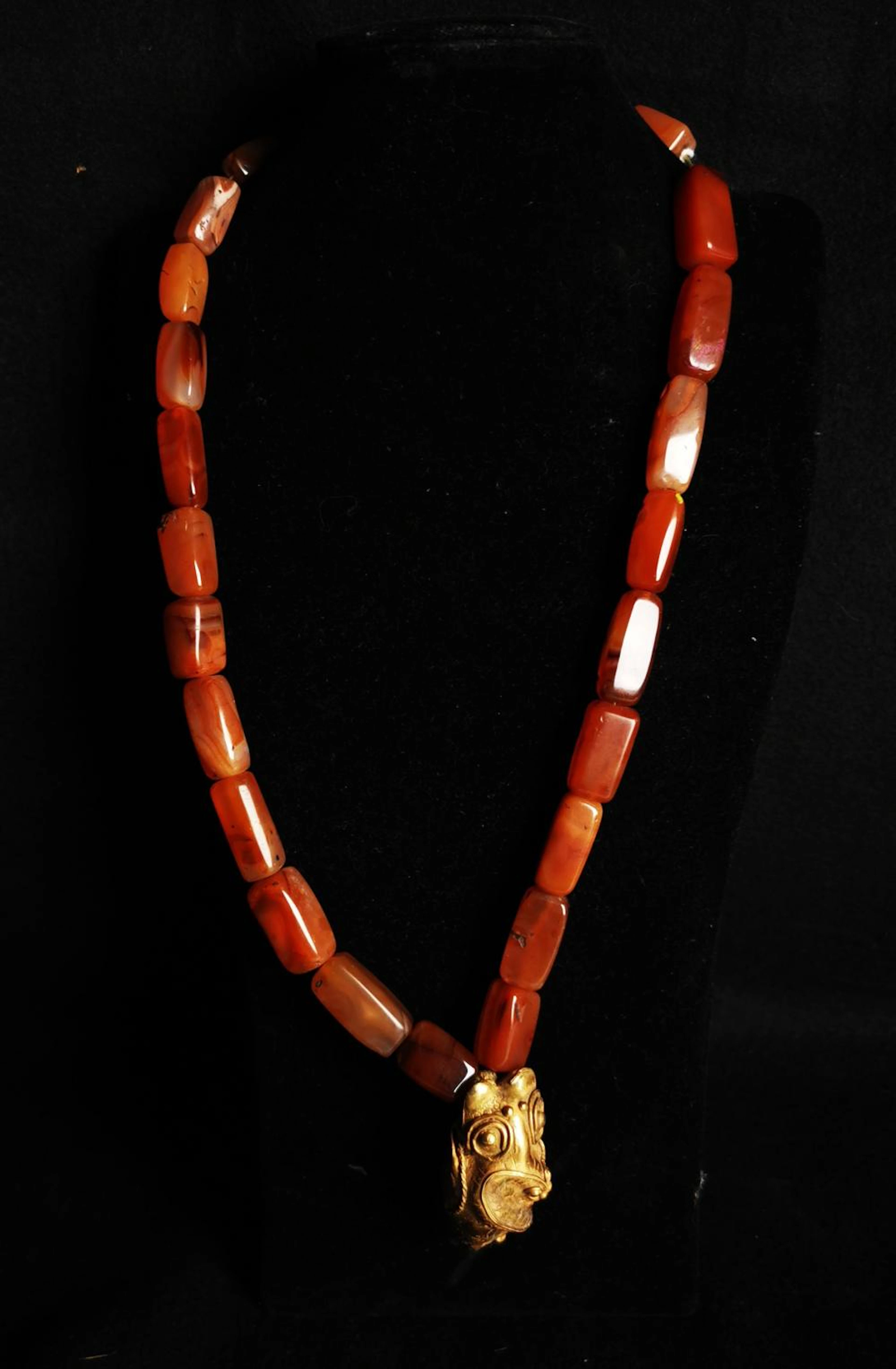 Ancien collier composé de perles en cornaline, orné d'un bijou en bas or (