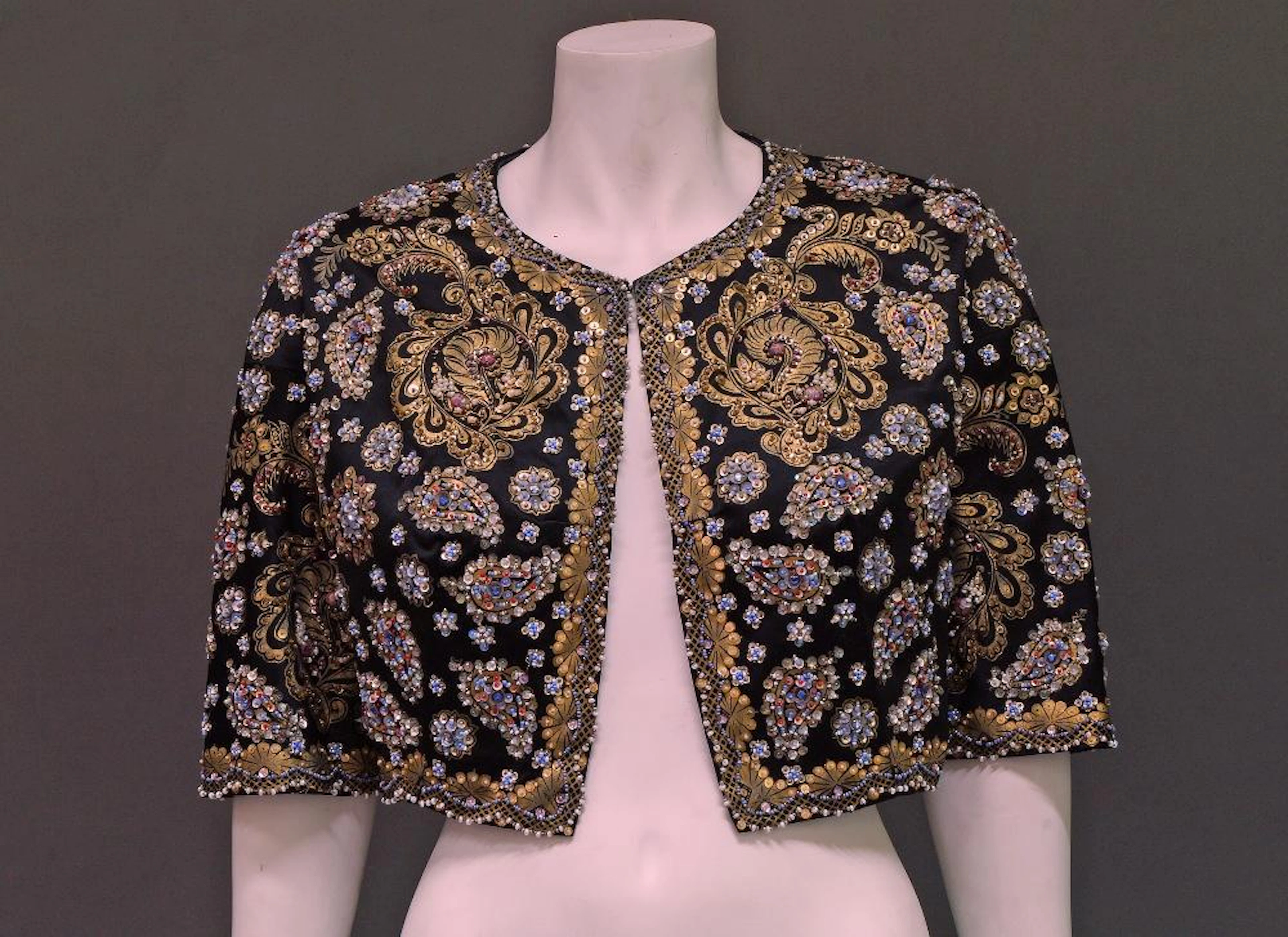 Lilly Dache: A black satin bolero jacket, 1940s, printed with gold