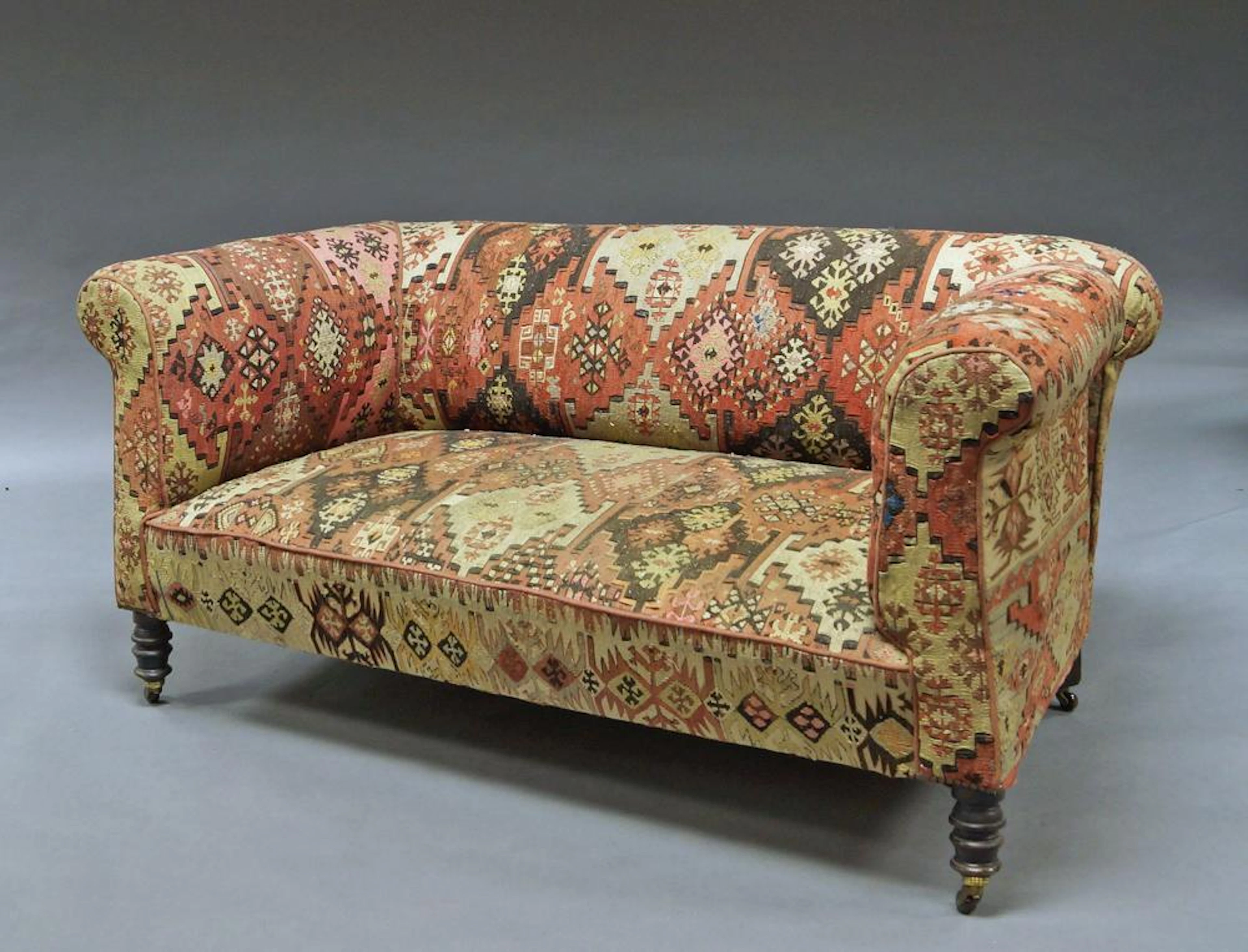 A Victorian Chesterfield type sofa, overall covered in Kelim carpet