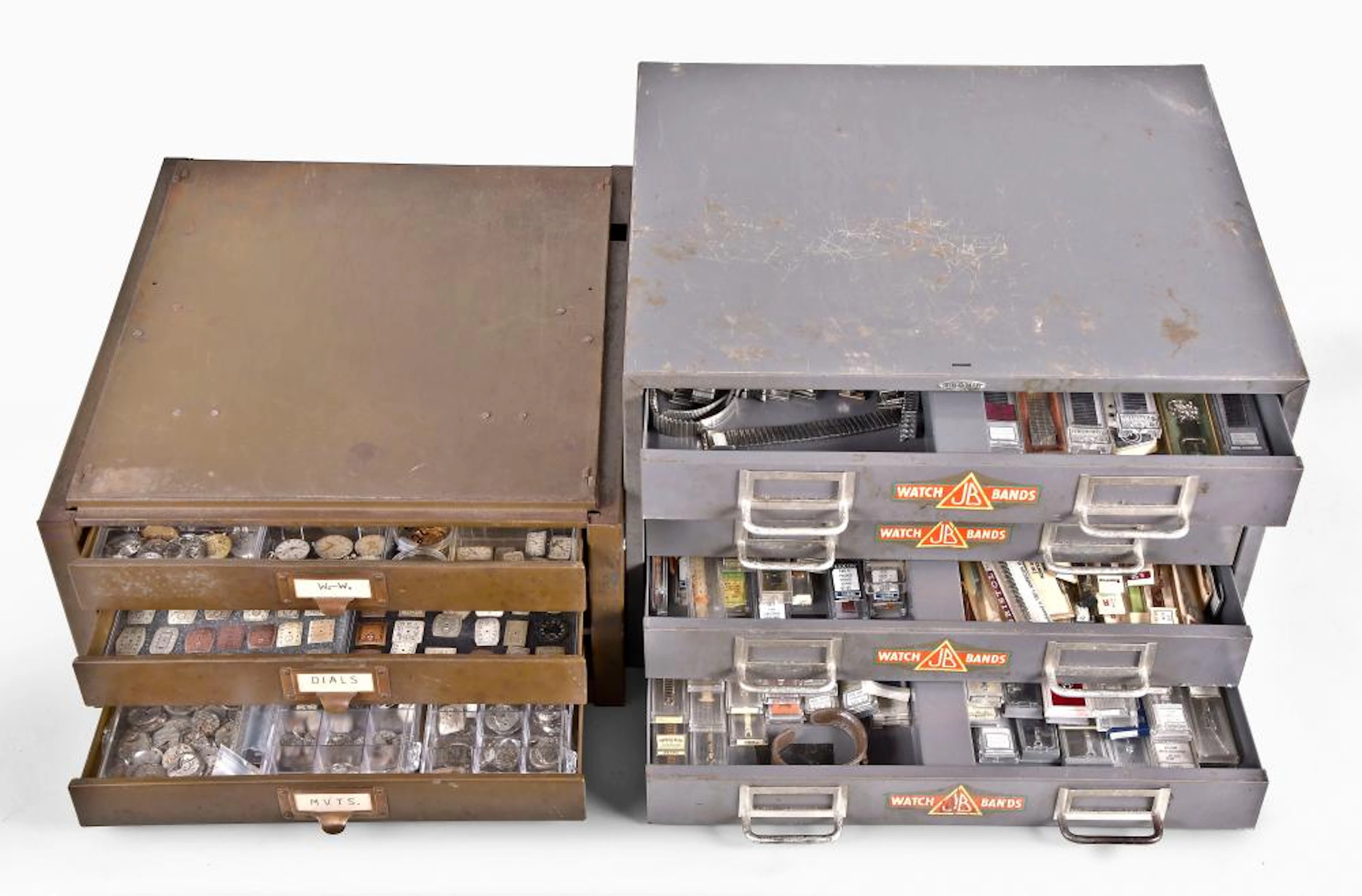 A lot of two metal cabinets containg wrist watch cases movements and watch bands