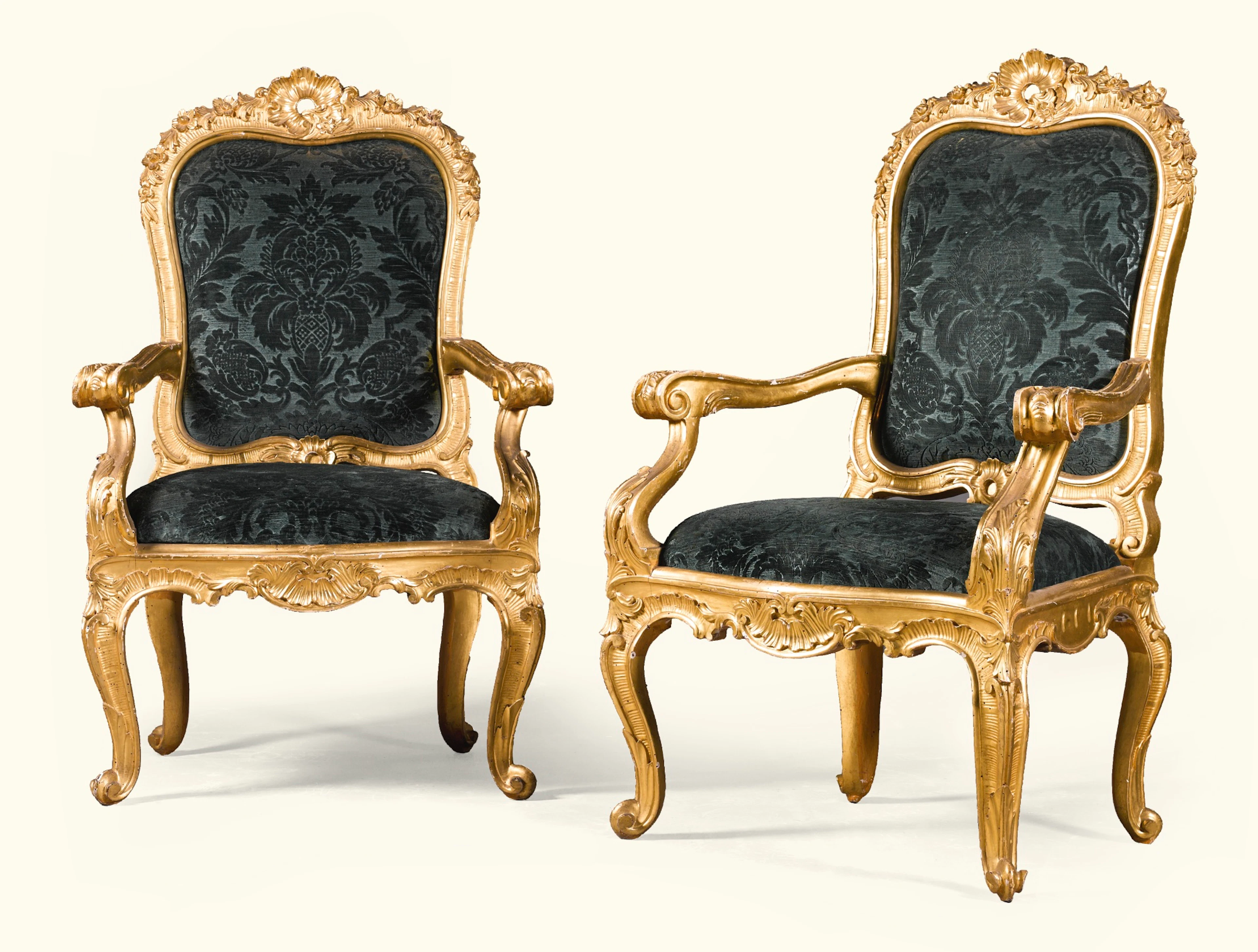 A pair of italian carved giltwood armchairs, in the rococo manner