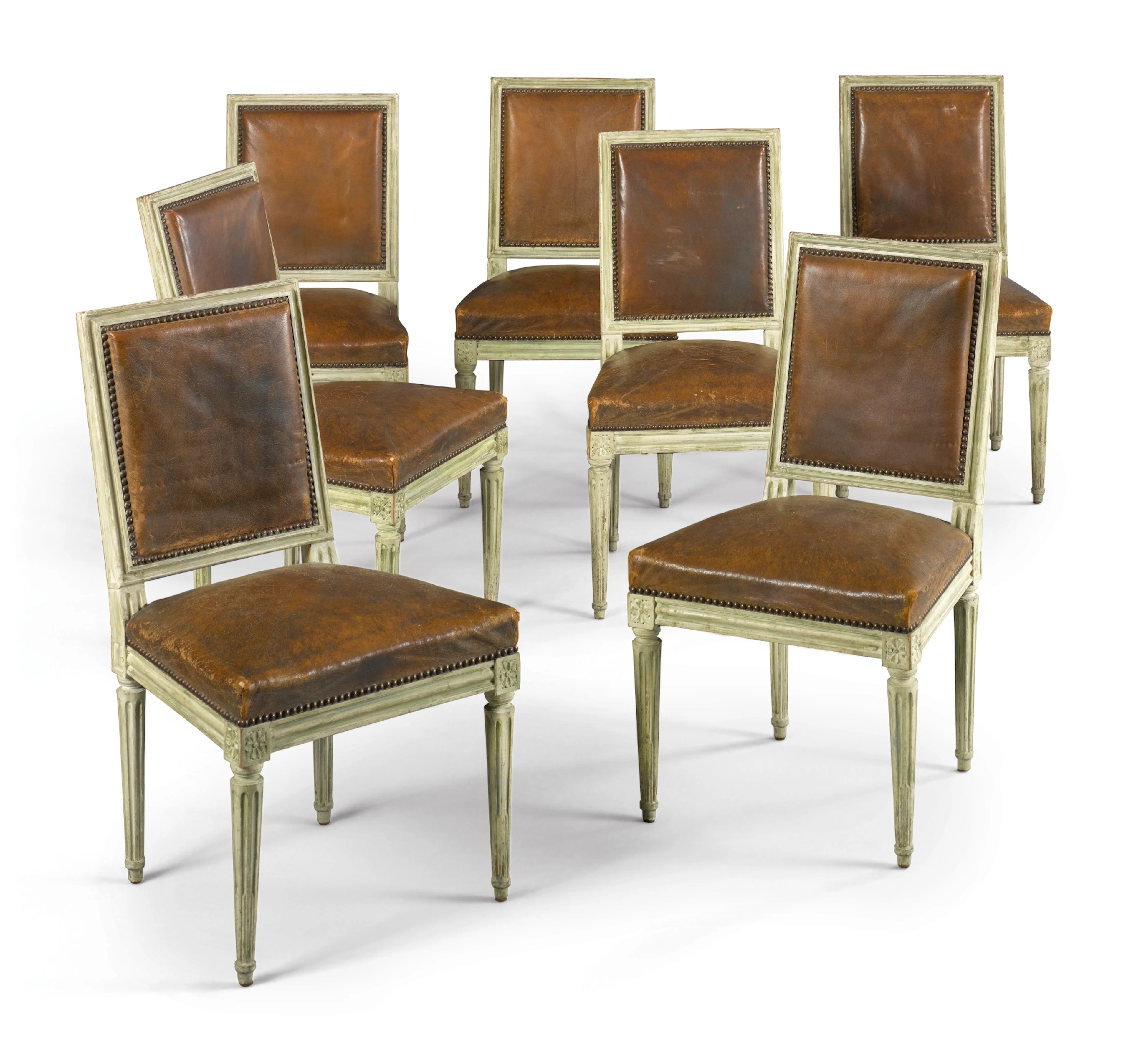 A set of seven louis xvi carved and white-painted side chairs circa 1775
