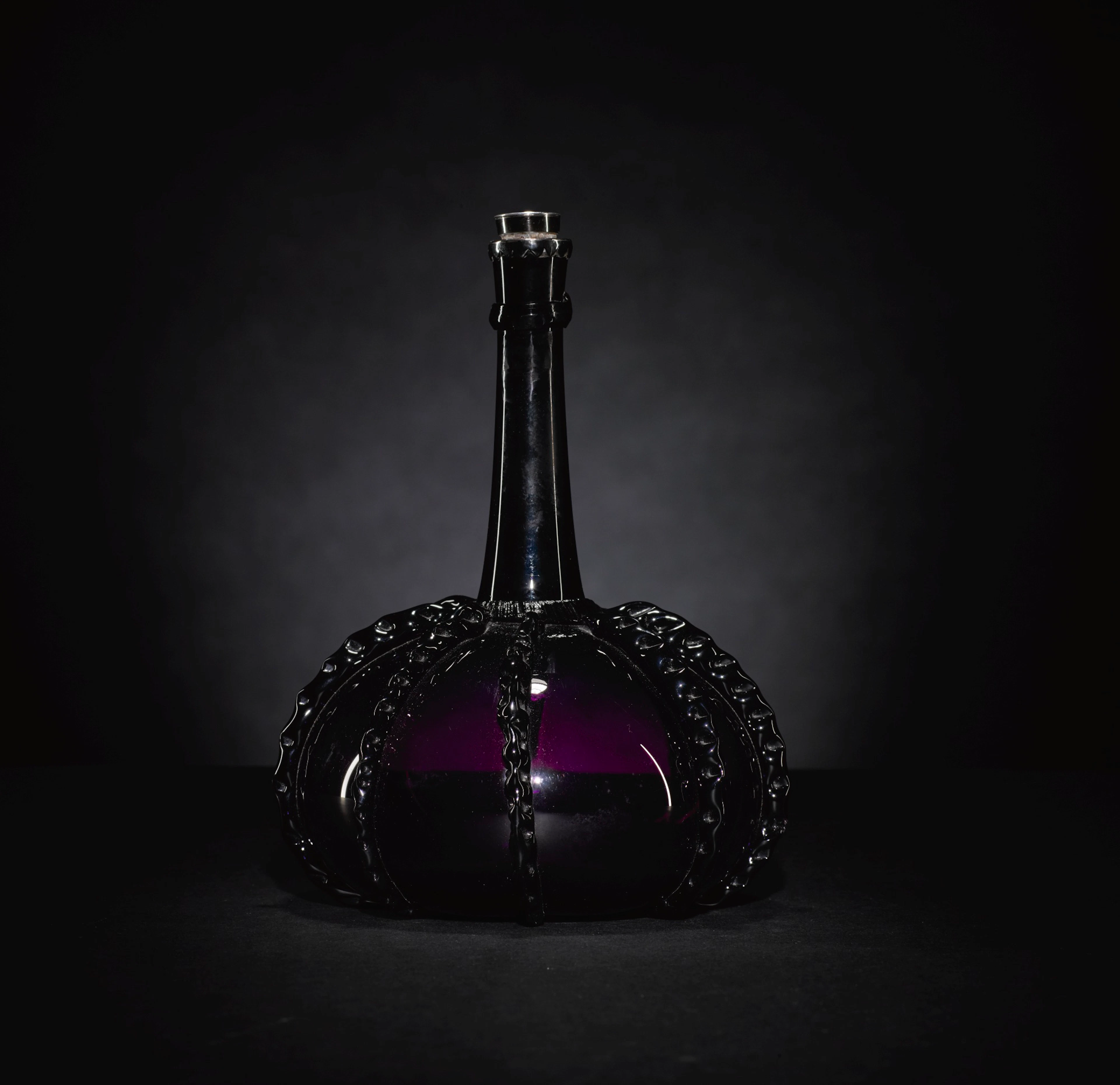 A dutch amethyst-tinted glass bottle, late 17th/ early 18th century
