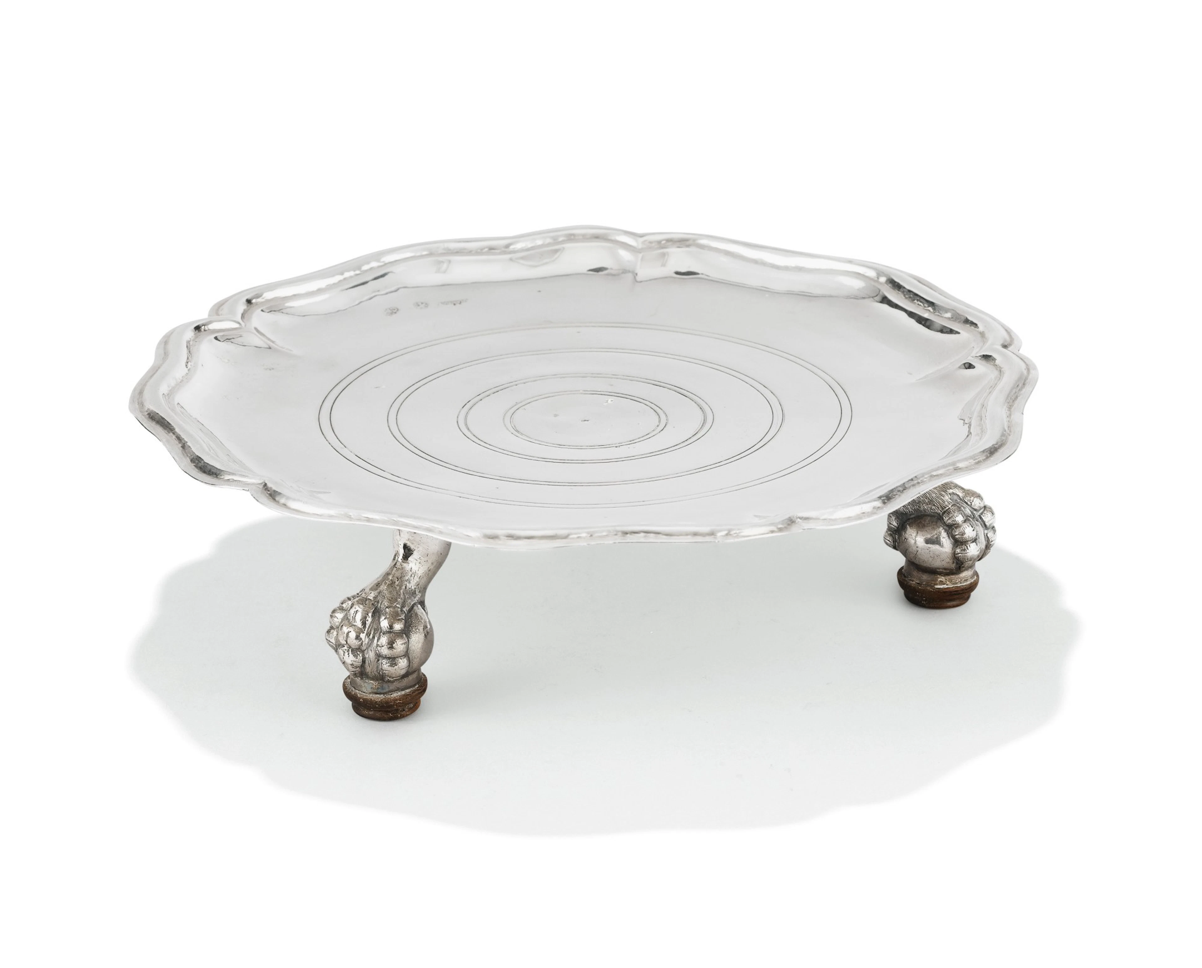 A silver spanish circular stand on three claw feet