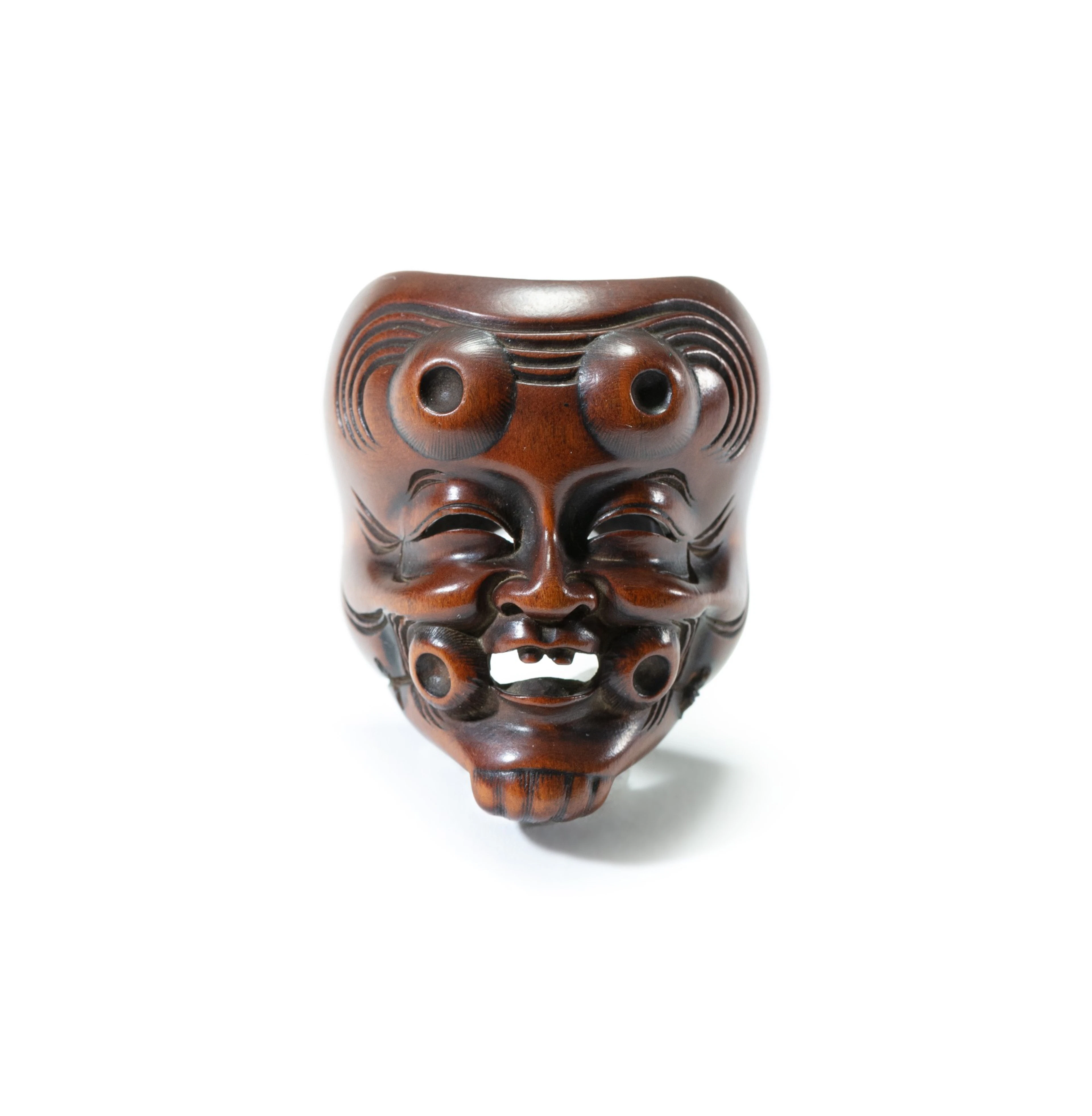 A carved wood study of a Noh theatre mask