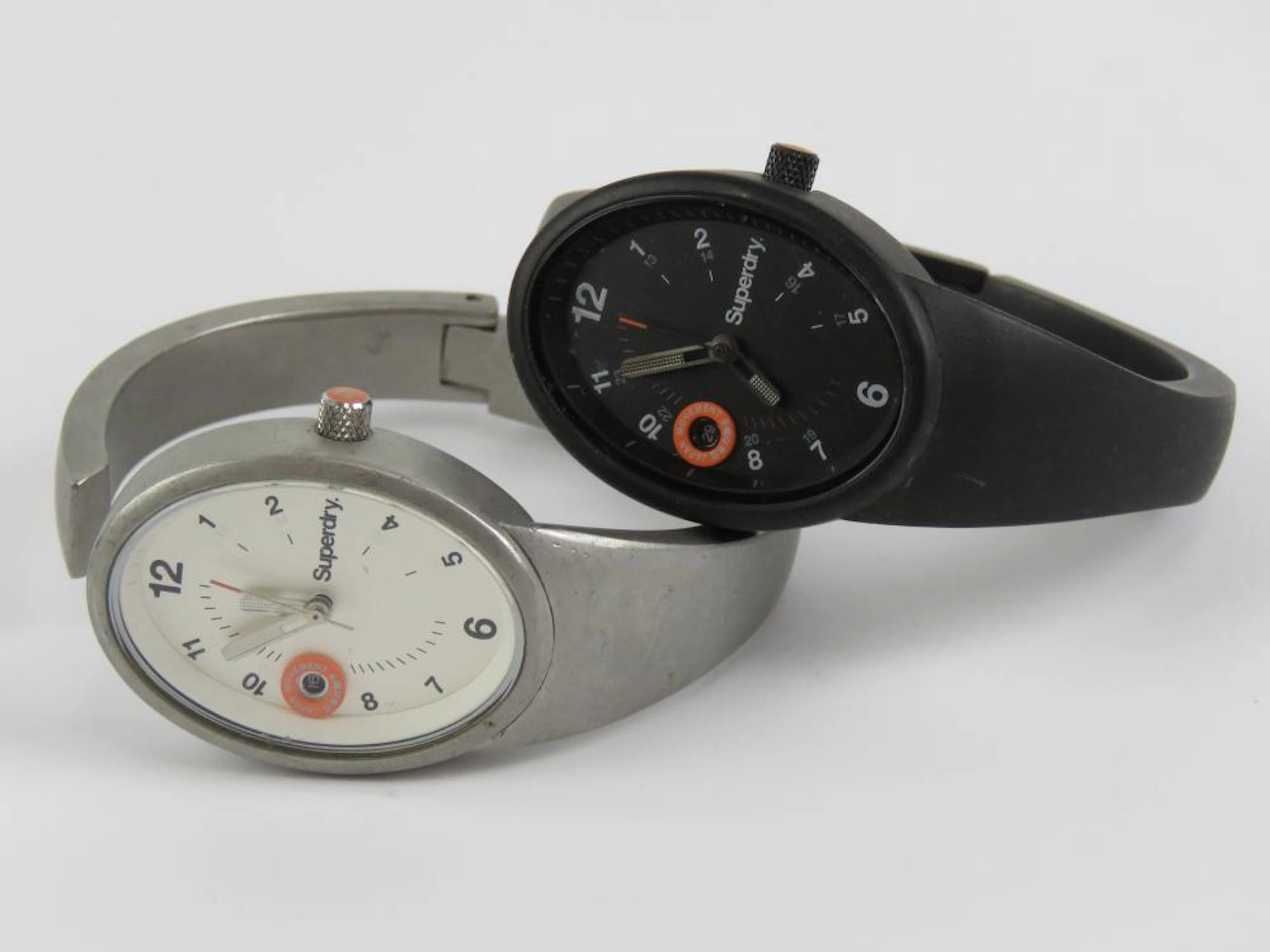Two stainless Superdry watches; one in black having black...