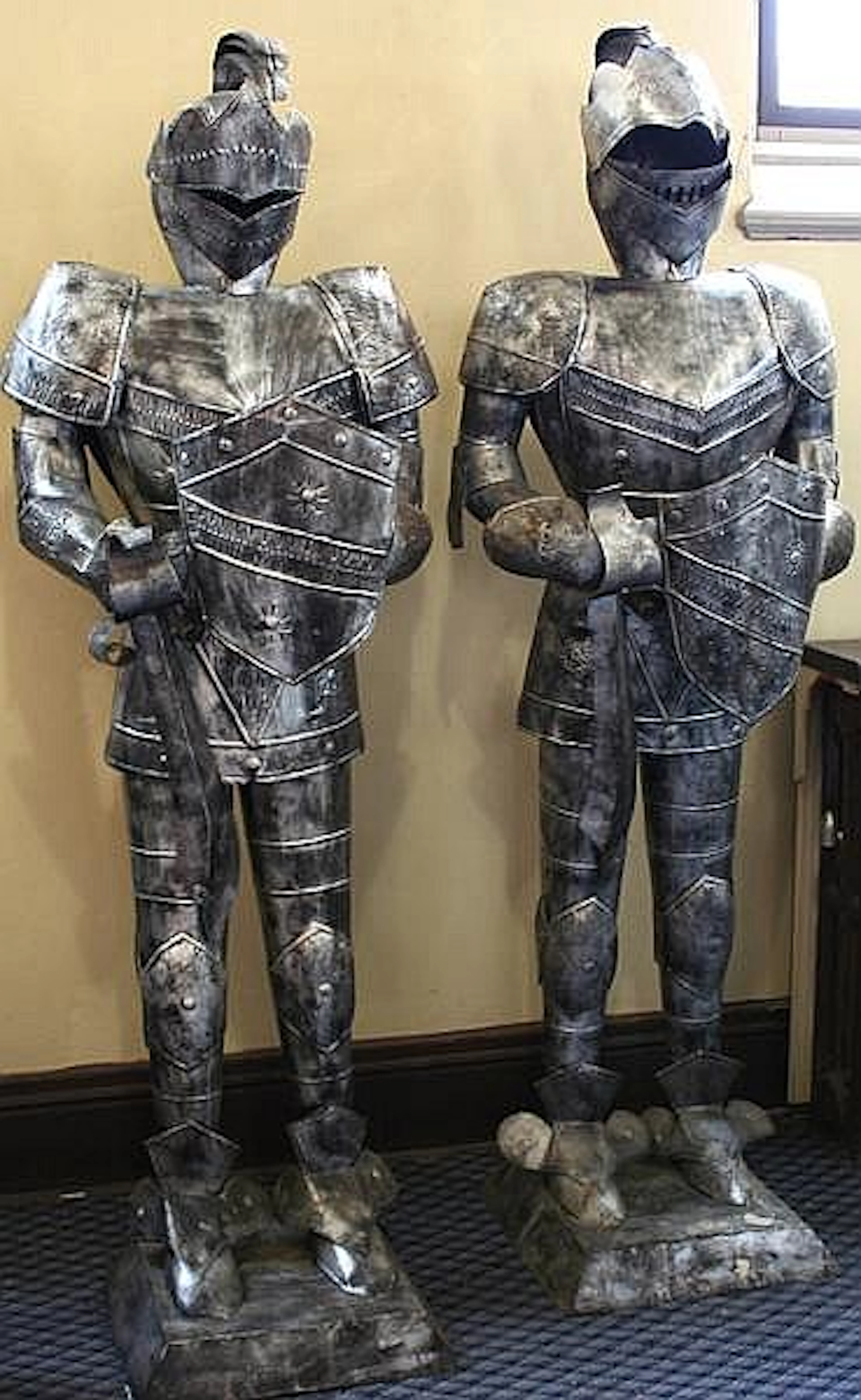 PAIR OF METAL KNIGHTS IN ARMOR. Pair of Mexican hammered tin medieval knights in armor with shield and sword, both set on raised square bases. Marked: gauntlet on right hand stamped: Mexico. Size: 81'