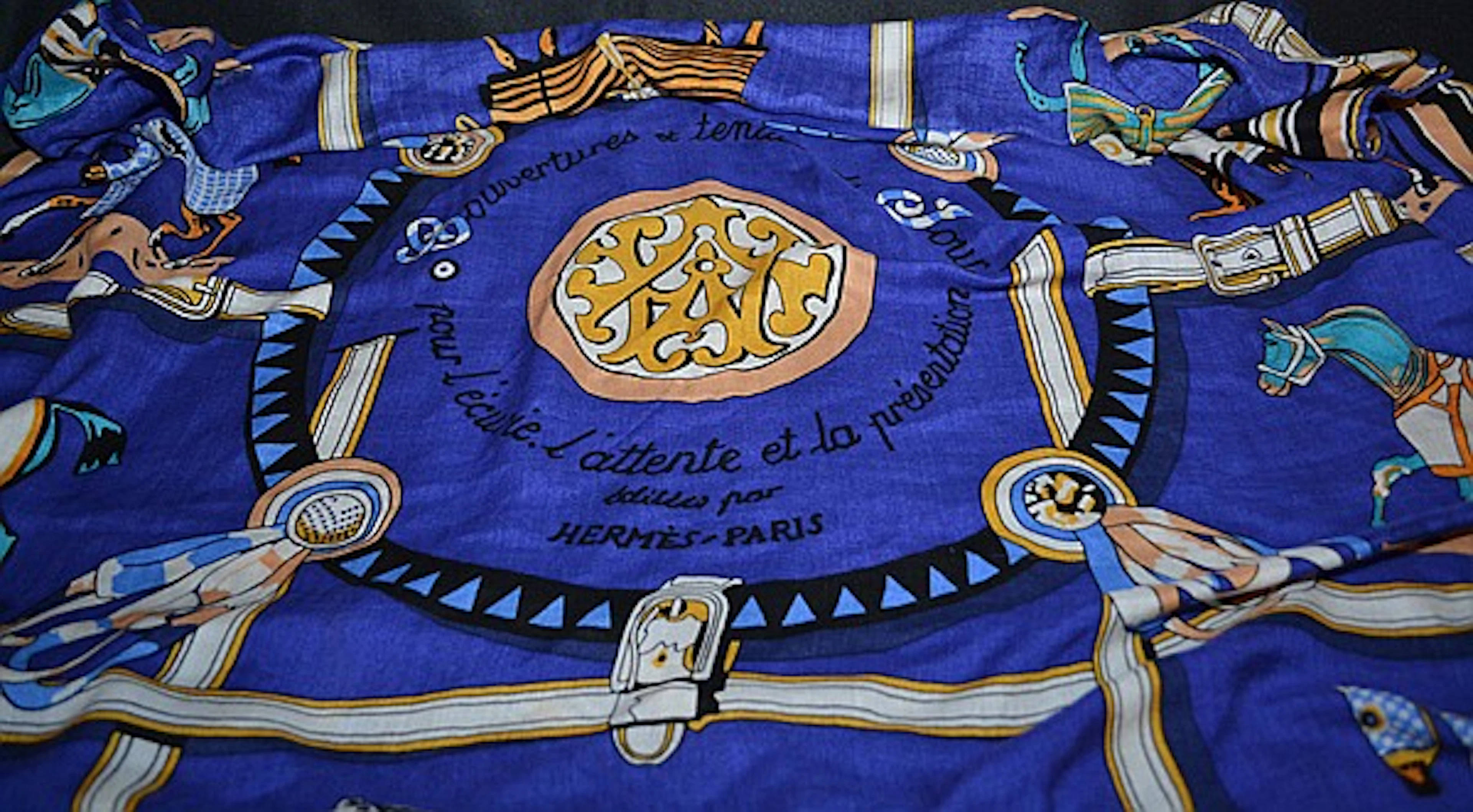 VINTAGE HERMES SILK SCARF (First introduced in 1974) 'Couvertures et Tenues de Jour', in blue, signed Hermes in print. Condition: age appropriate wear. Dimensions: 35'' X 35''. Lot also includes unmar