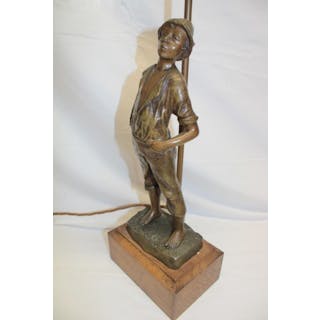 A bronzed spelter table lamp in the form of a young boy...