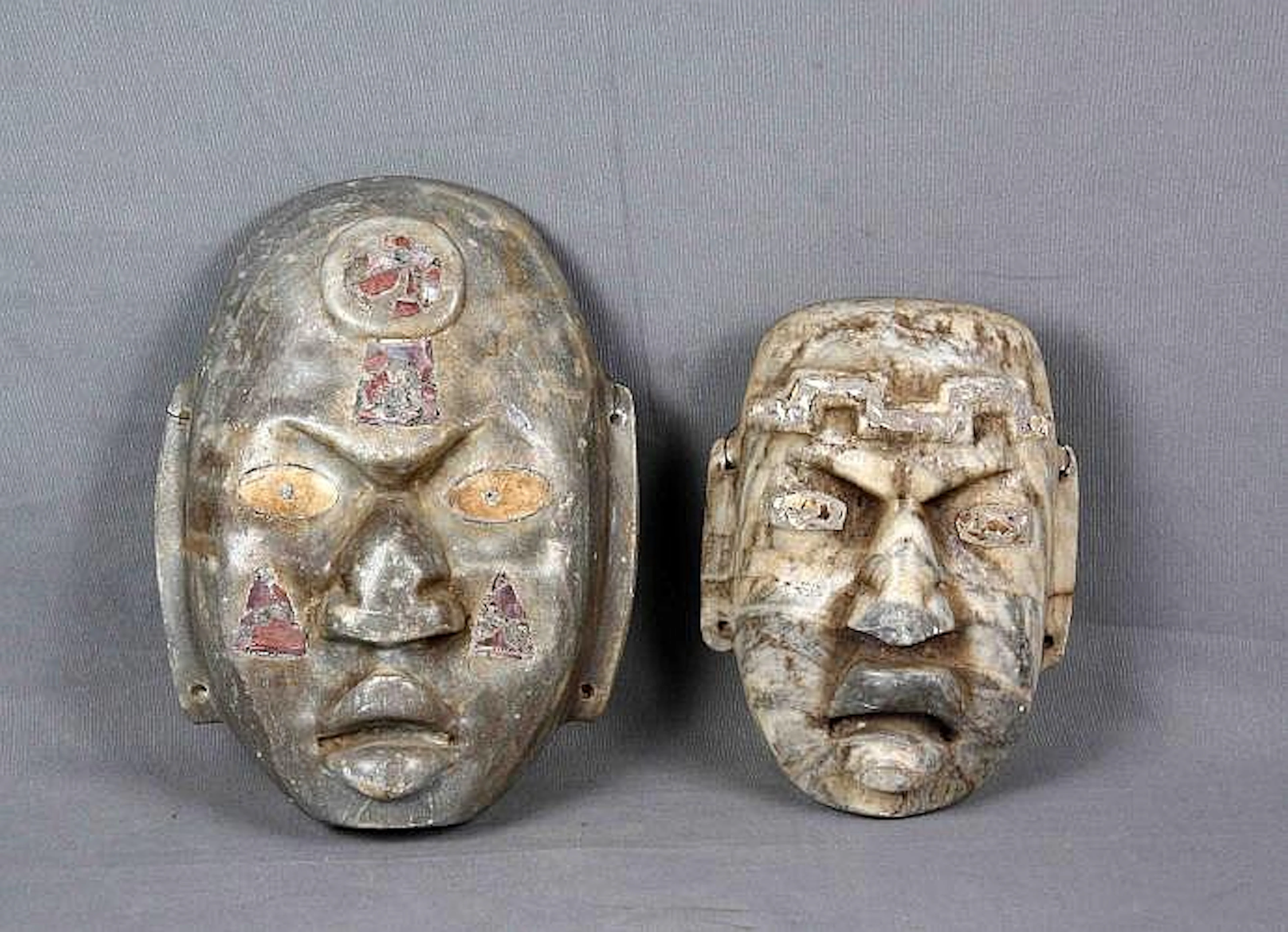 Pareja de máscaras talladas en mármol. Med.: 24x18 cm. y 31x