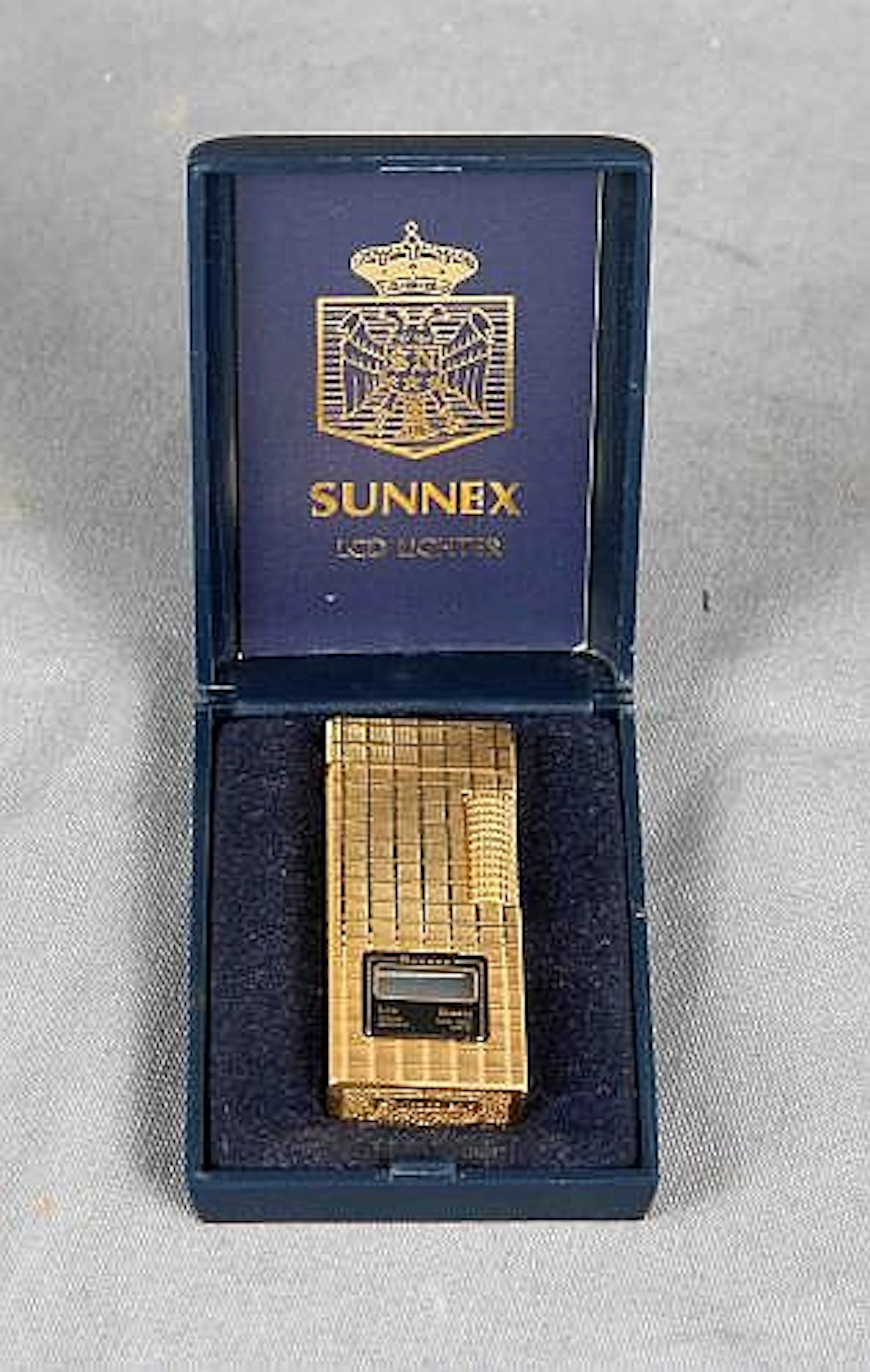 Mechero de la firma SUNNEX, chapado en oro, con reloj digita