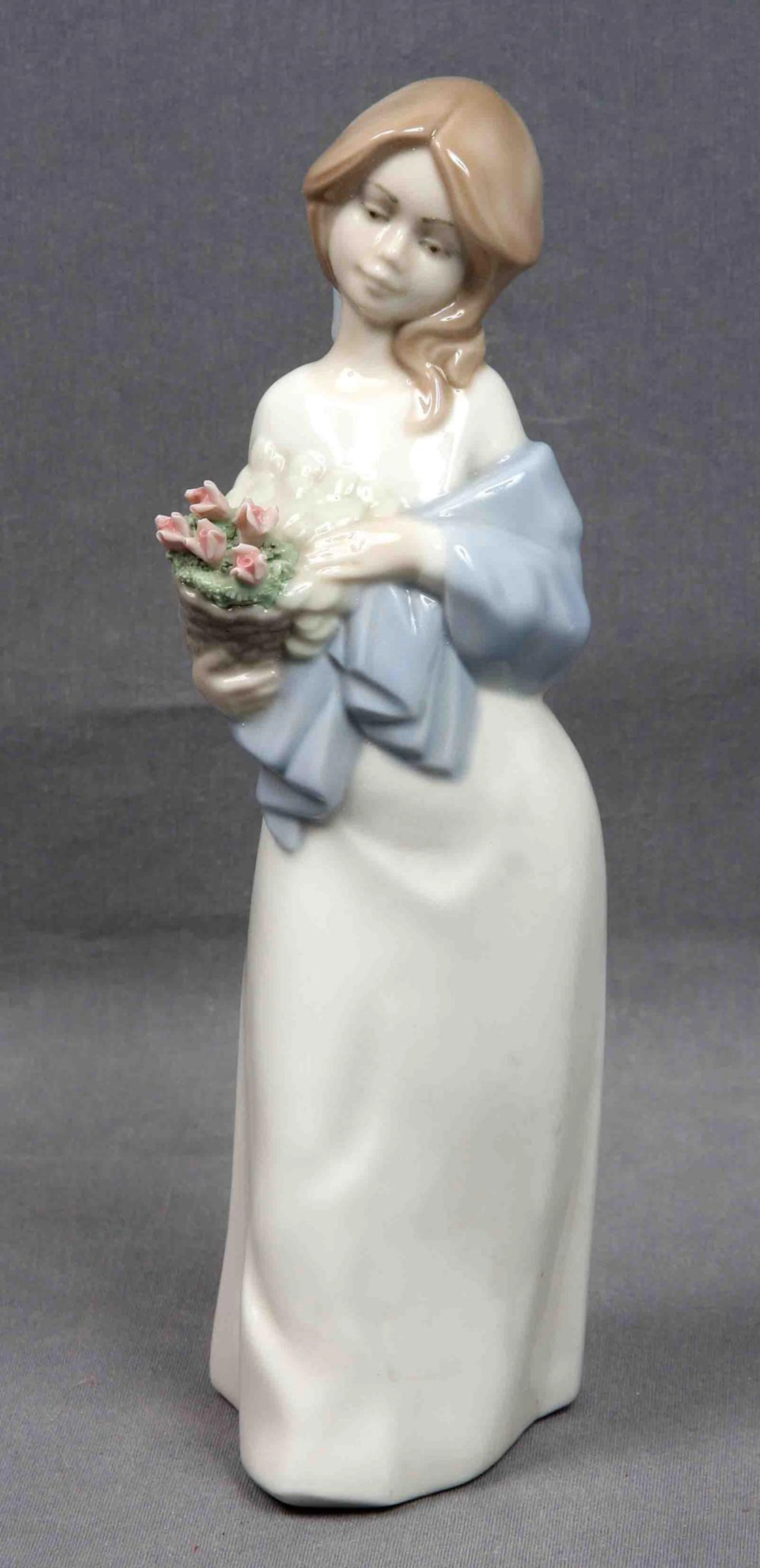 Figura de joven con cesta de flores. En porcelana