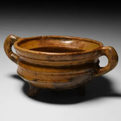 A glazed ceramic tripod vessel with carinated body and everted rim ...