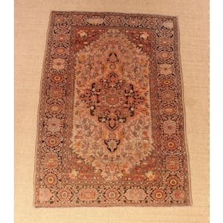 A Small Antique Persian Carpet woven with a centre...