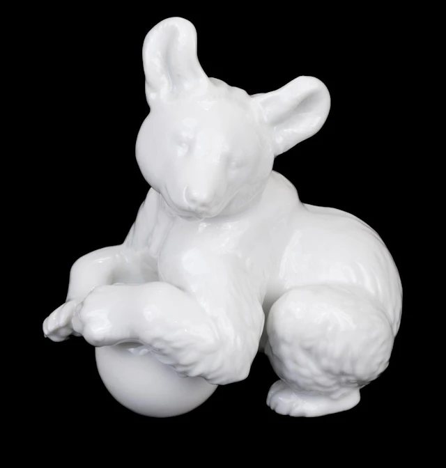 Third Reich. Allach bear, white glazed modelled with a ball