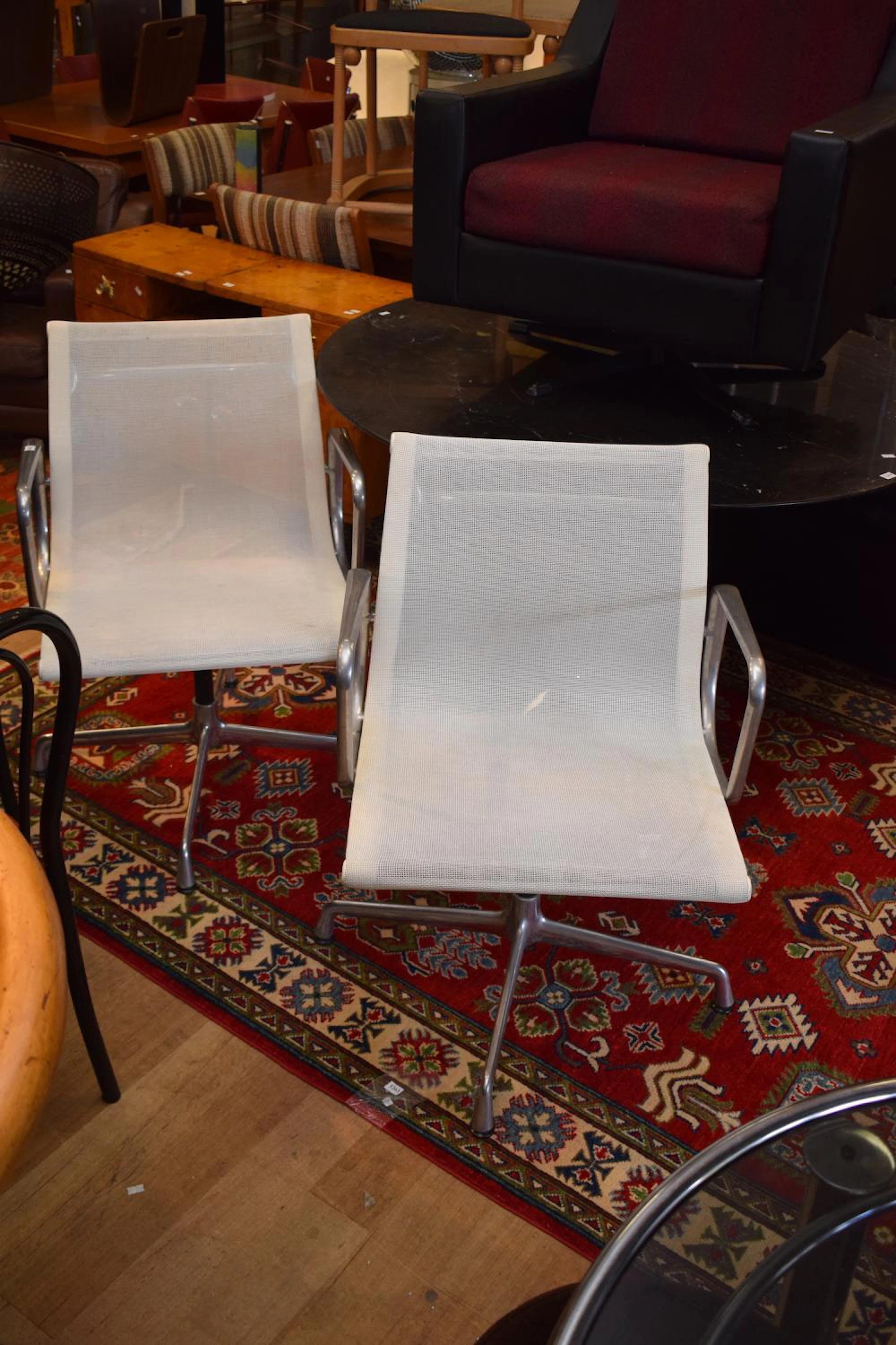 A PAIR OF WHITE EAMES OFFICE SWIVEL CHAIRS BY VITRA (A/F)