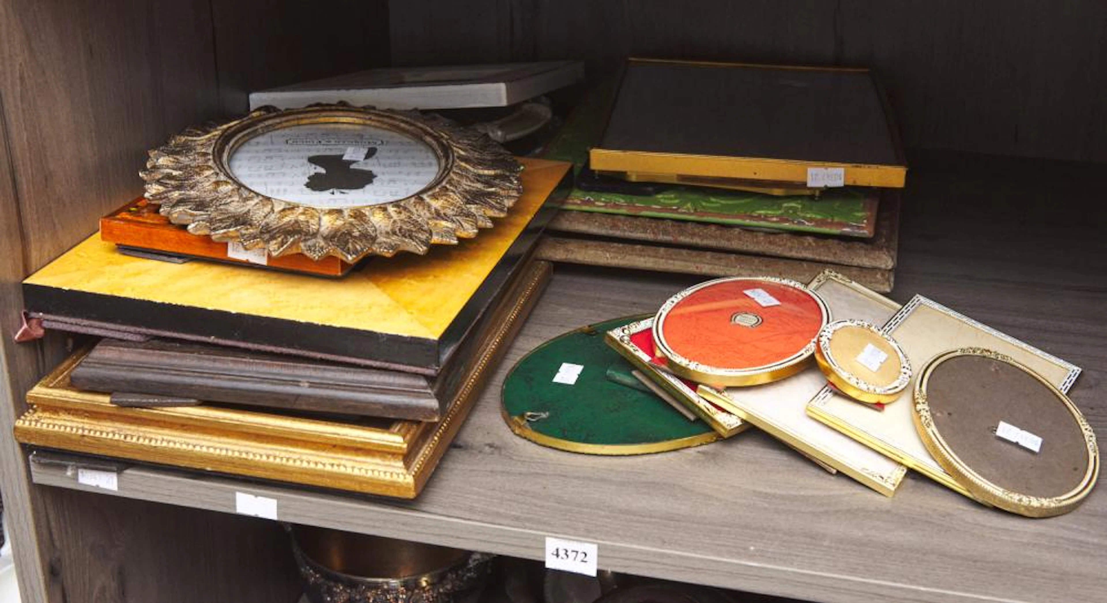 A SHELF OF DECORATIVE FRAMES INCLUDING DANISH DESIGN