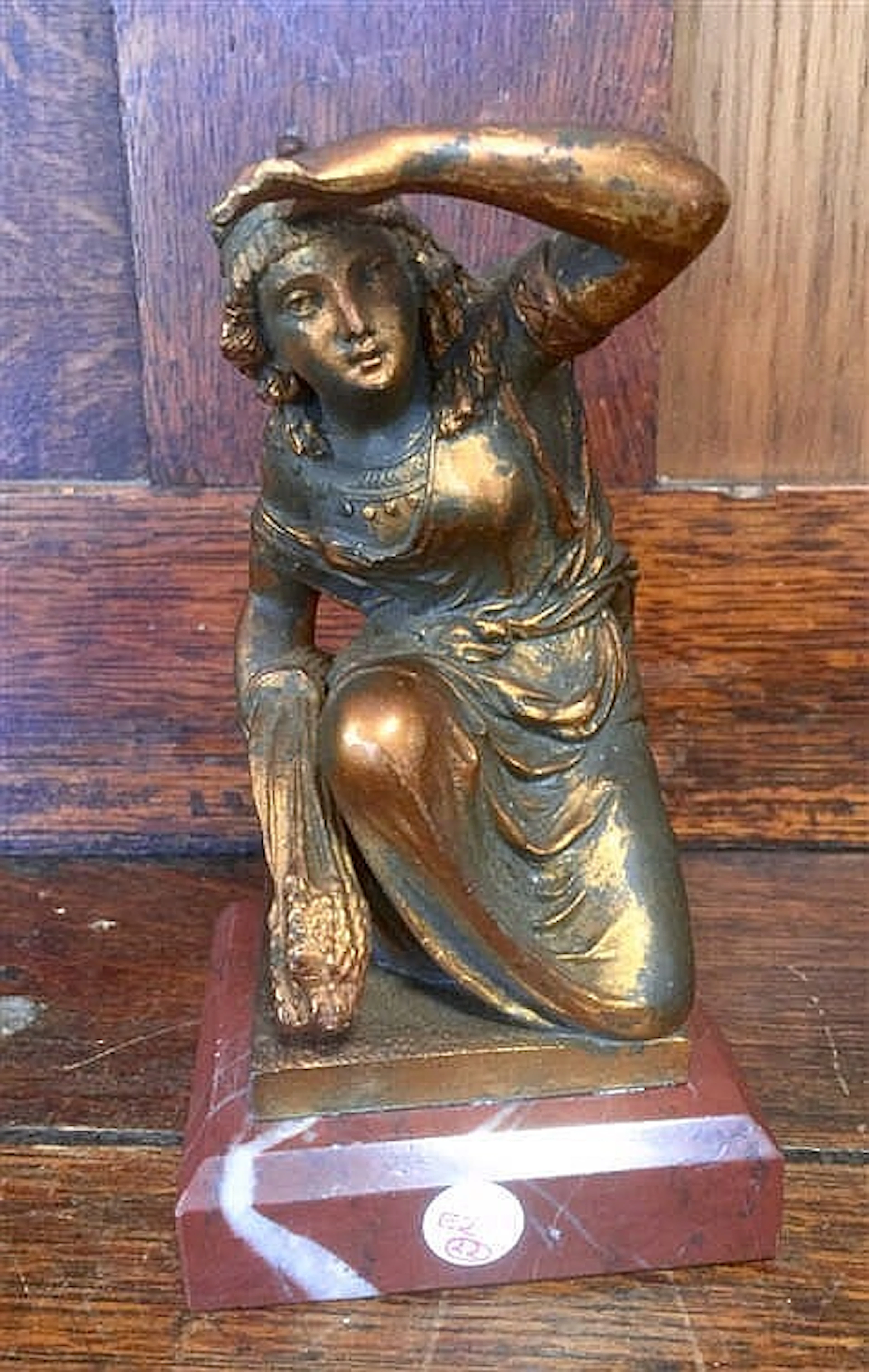 Bronze figure of a lady crouching, holding a wheatsheaf in her right hand