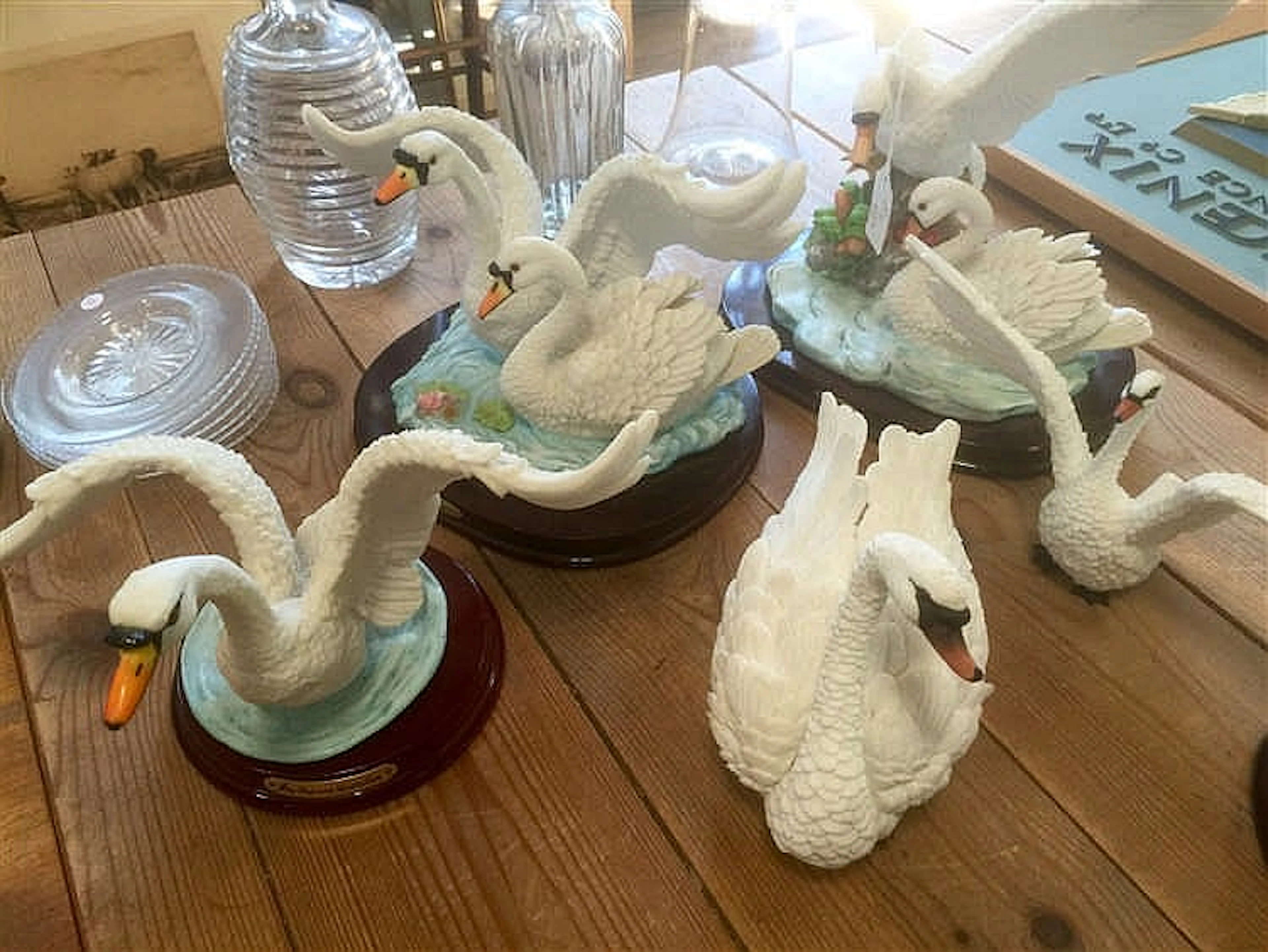 Five models of swans by Juliana & Leonardo collection, some on wooden plint