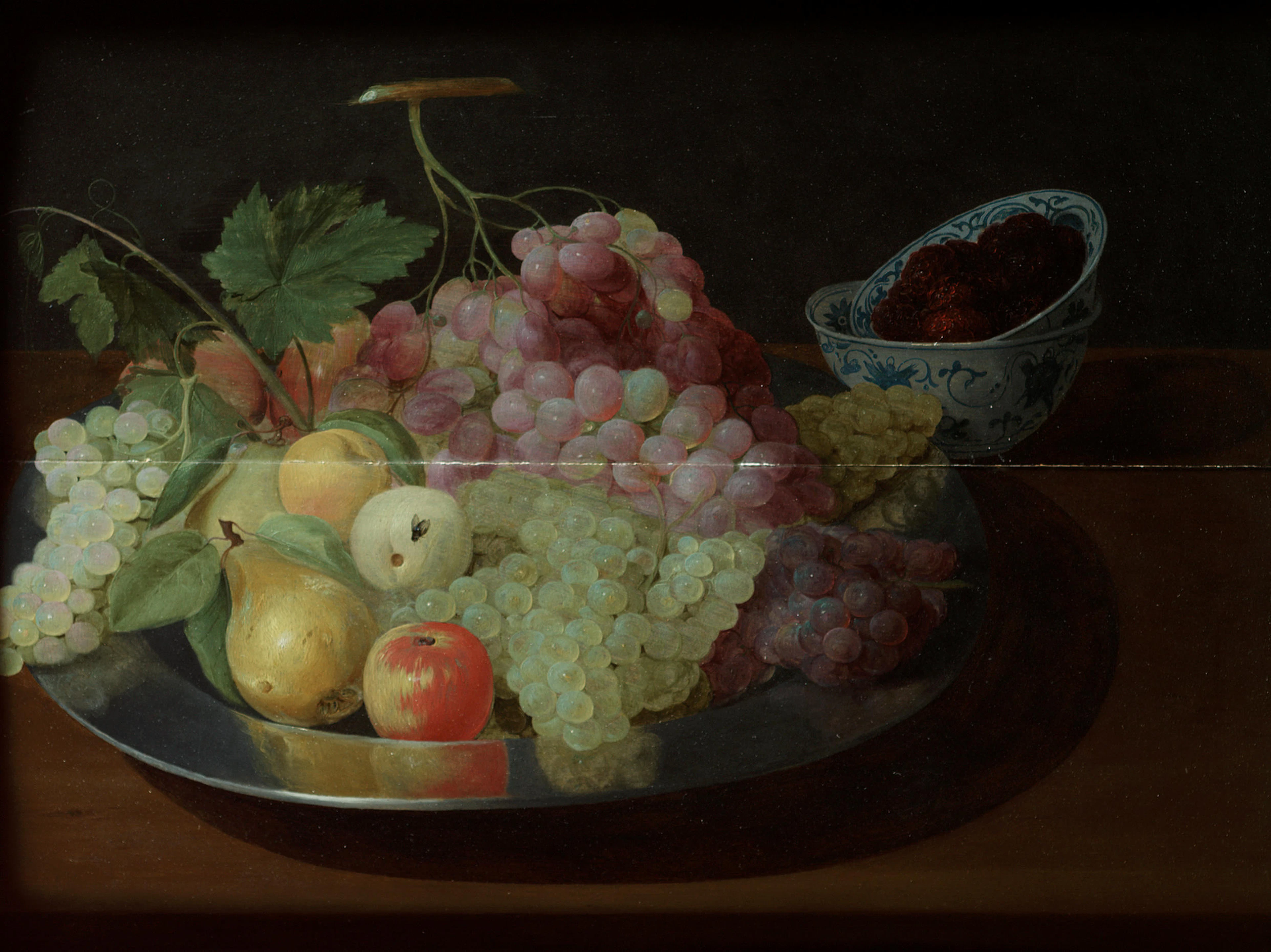 Grapes, a pear and apples on a silver salver, with a wan-li kraak bowl of raspberries
