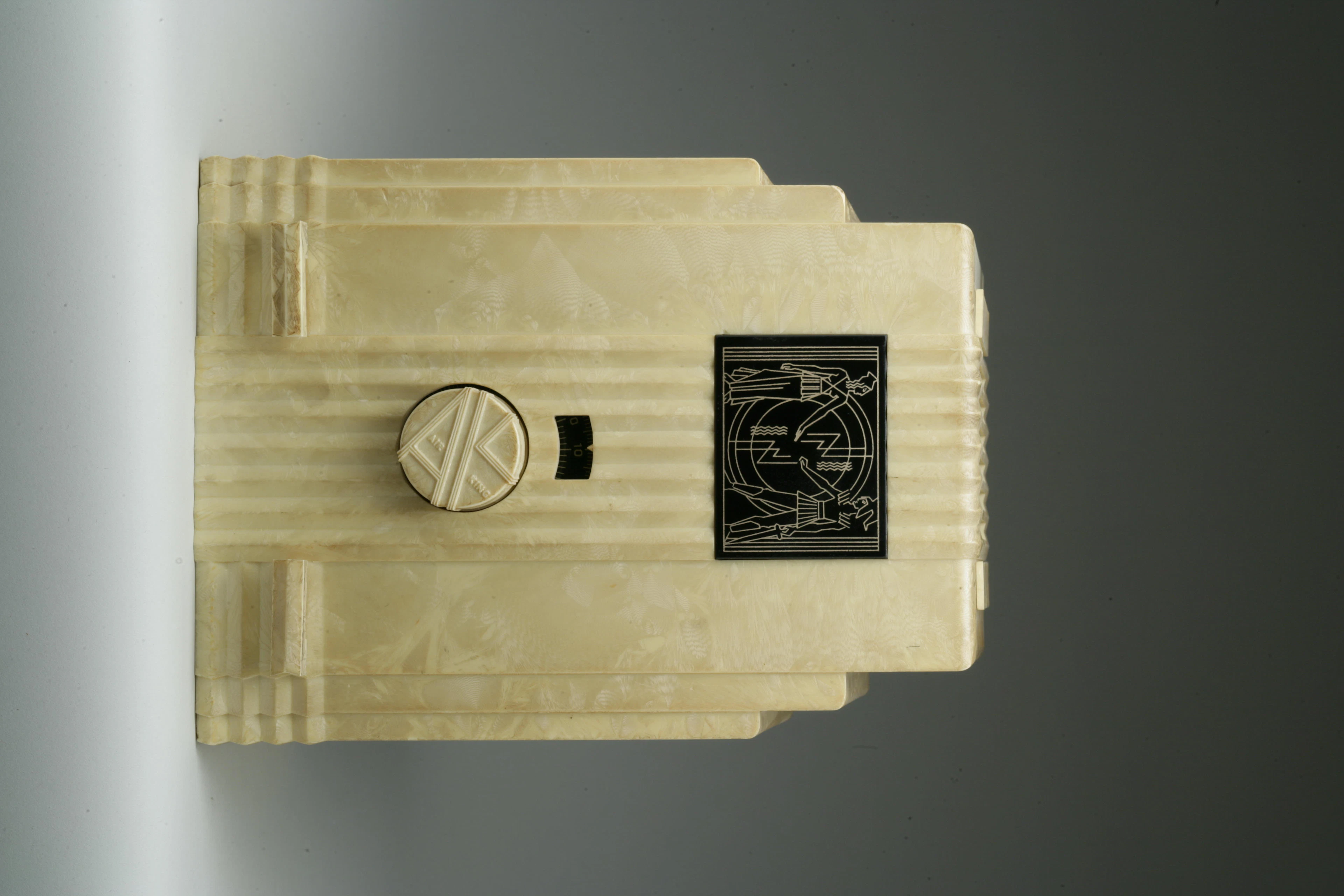 Air King 52 1933 White flocked case with white lever knobs and an Egyptian dial. Height 11 3/4in; width 8 3/4in; depth 6 3/4in