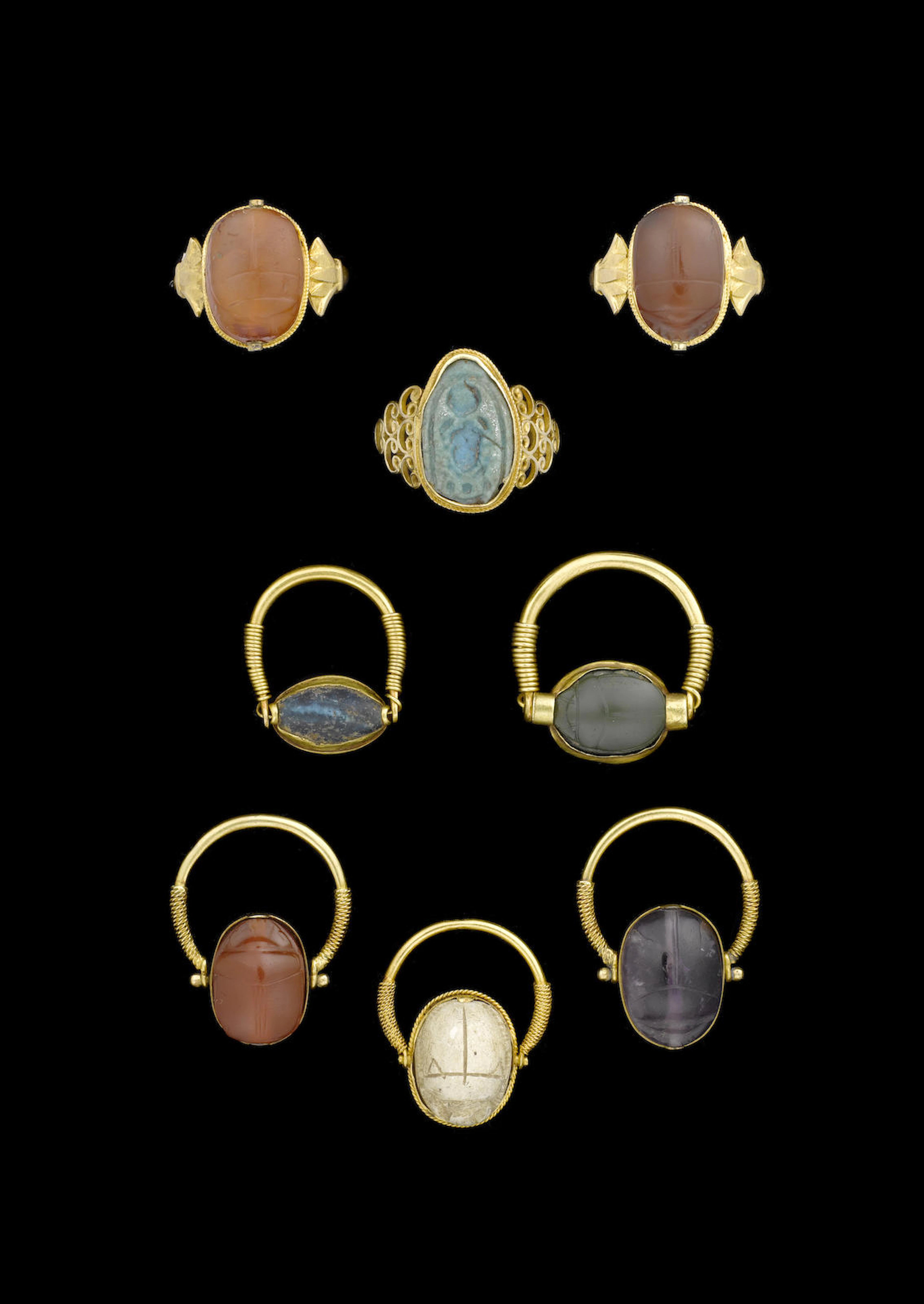 Six Egyptian hardstone and steatite scarabs an Egyptian turquoise glazed composition plaque and a blue glass cowroid, 8