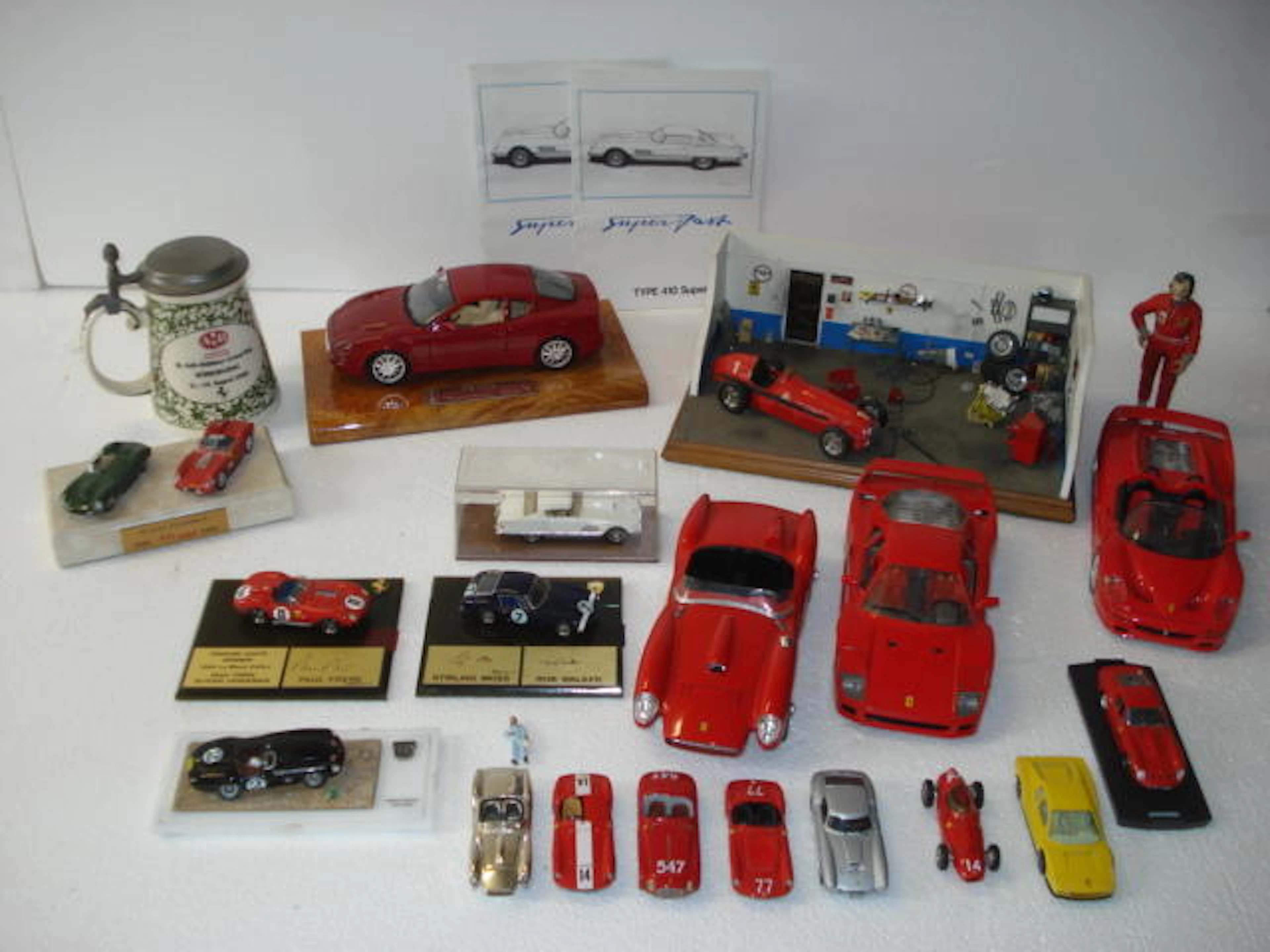 A detailed garage diorama with Alfa Romeo and a collection of Ferrari models,