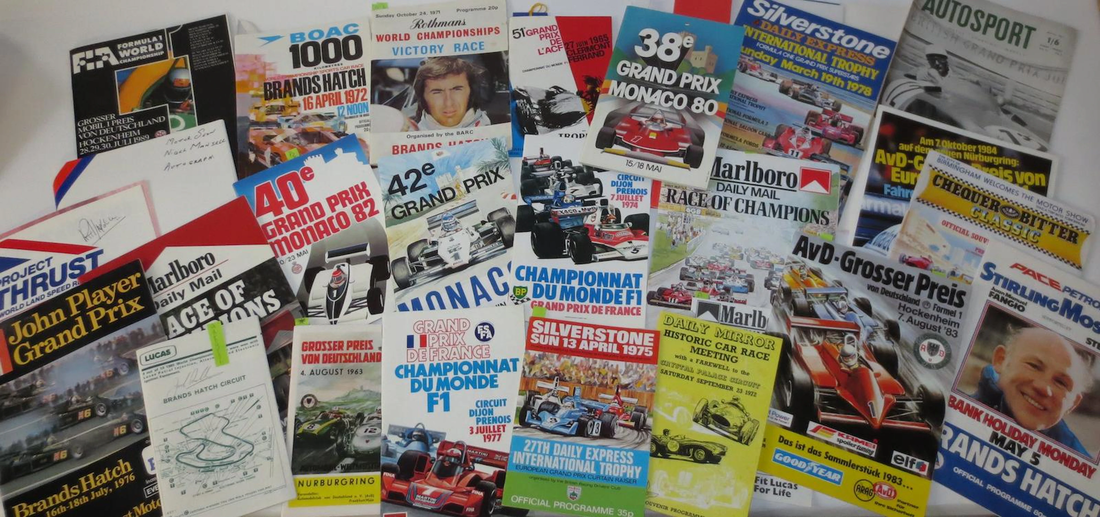 A collection of driver signed race programmes,
