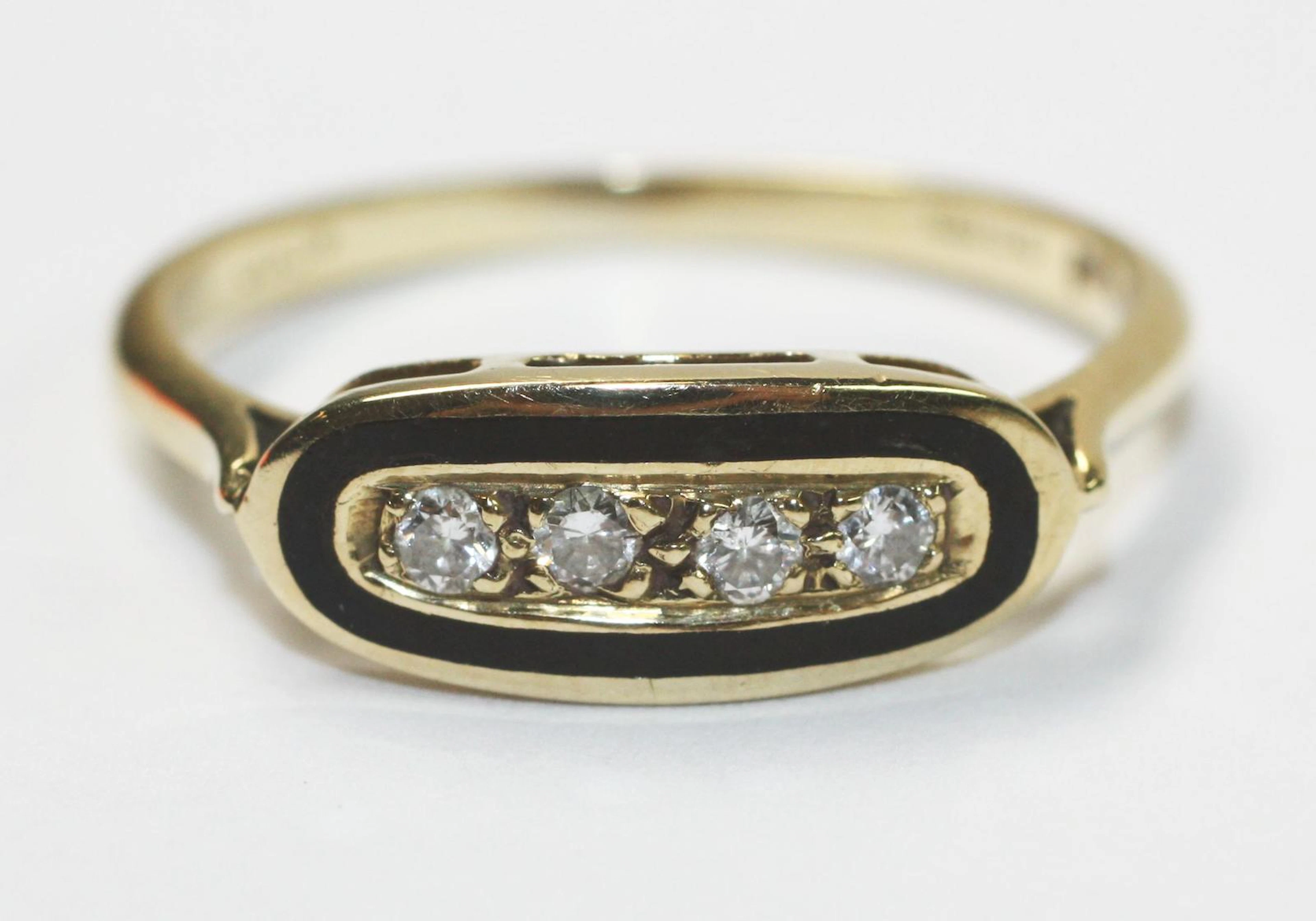 A diamond and black enamel ring,