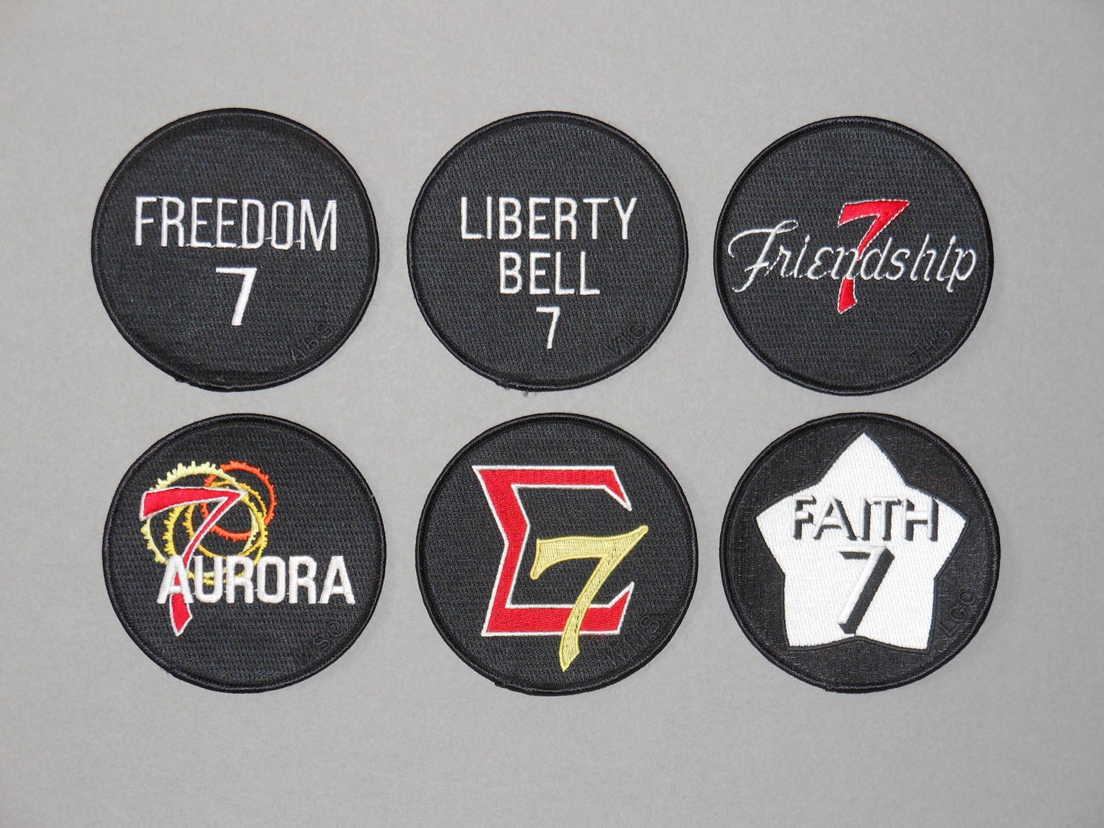 THE SIX MERCURY MISSION EMBLEMS.