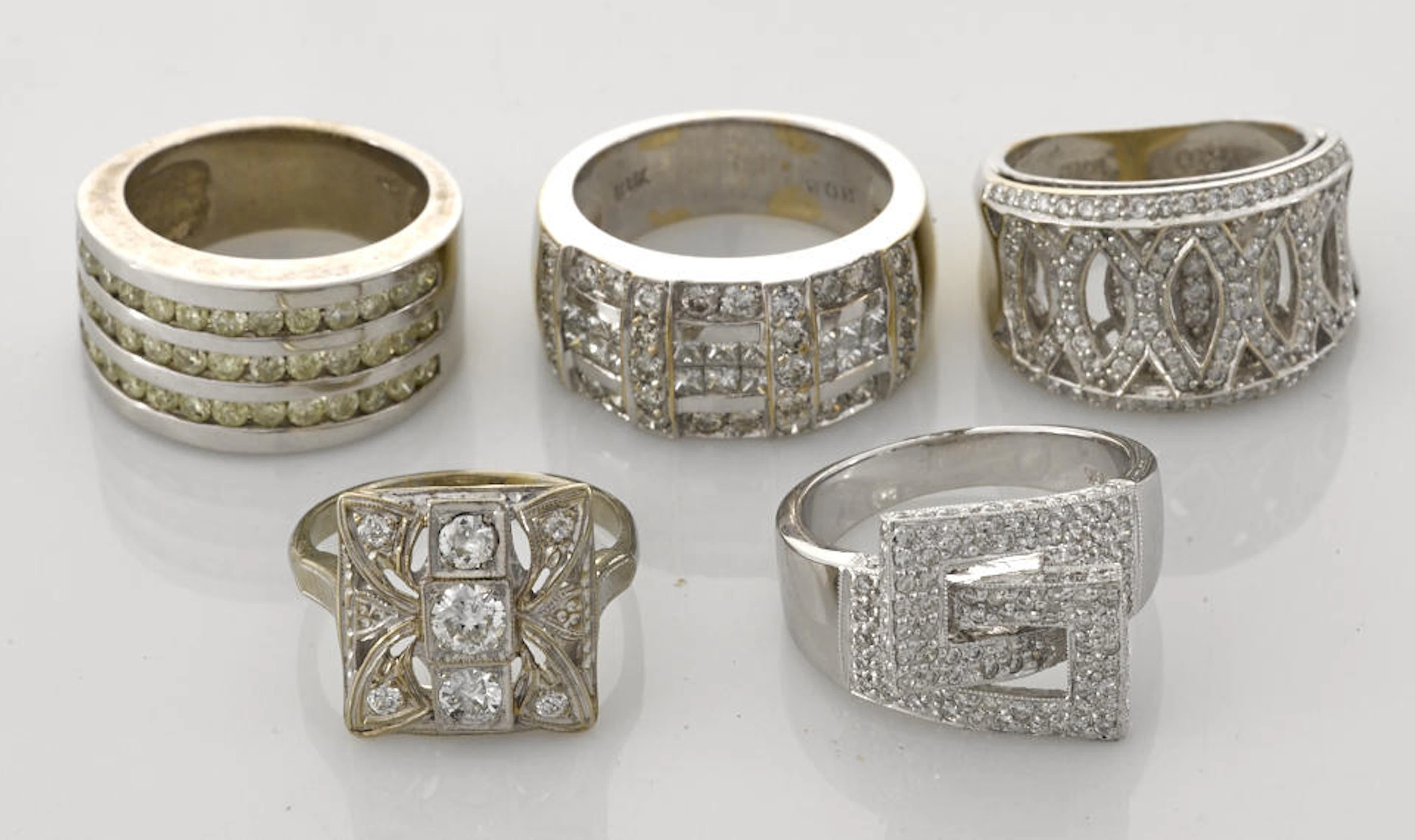 A collection of five diamond, 14k and 18k white and rhodium-plated yellow gold rings