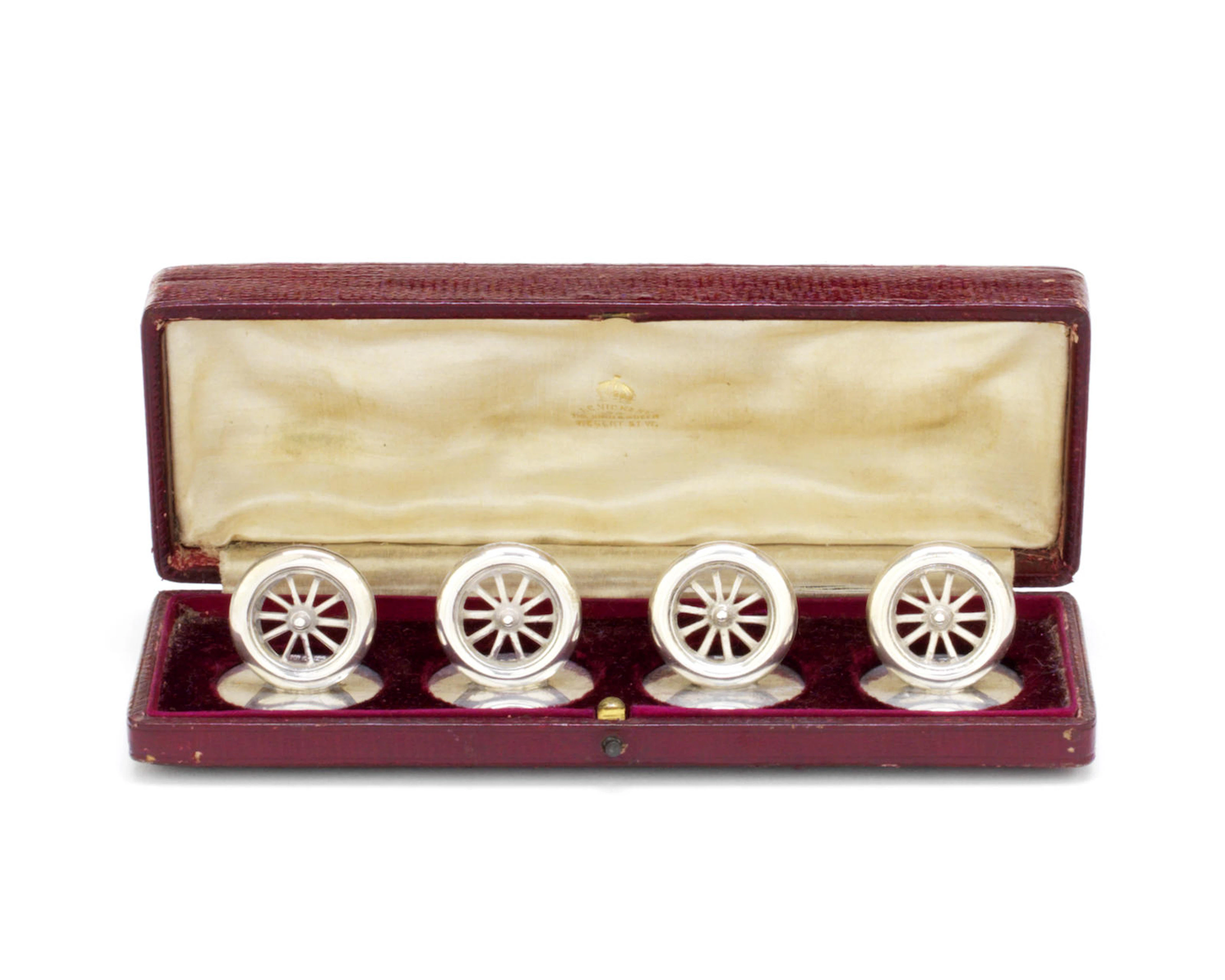 A cased set of four sterling silver 'wheel' place card holders, by J C Vickery of Regent Street, 1906,