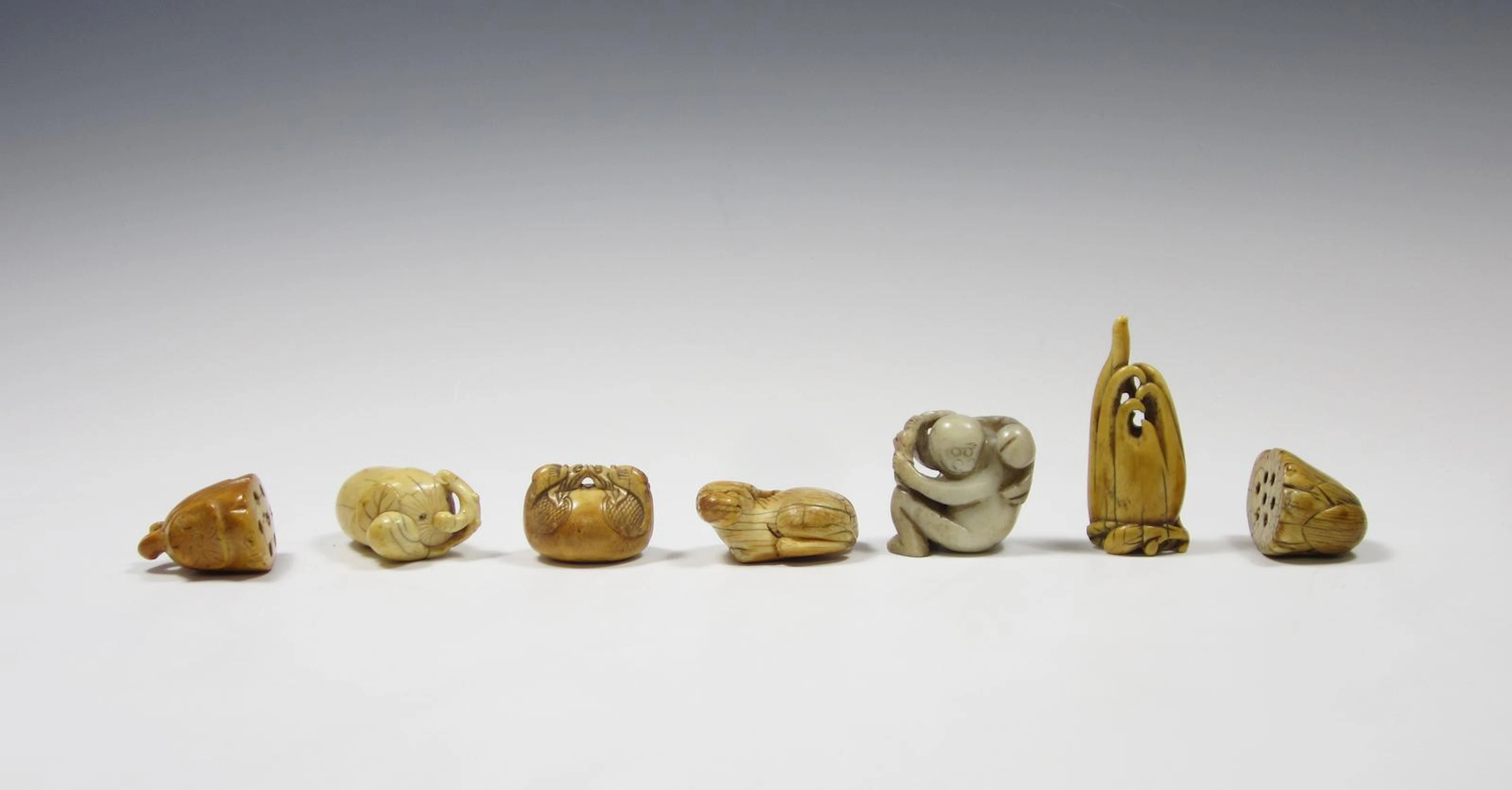 Six ivory and marine ivory netsuke and a small jade carving Meiji