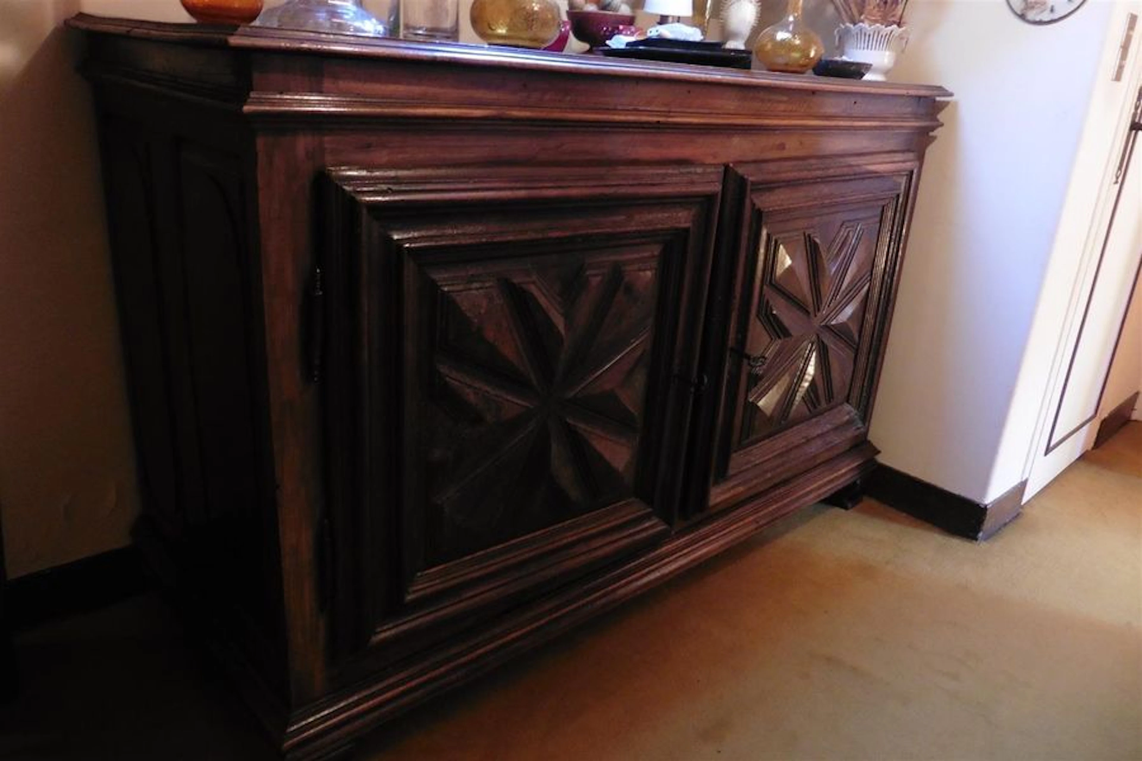 Buffet bas ouvrant par deux portes à décor sculpté de pointes...