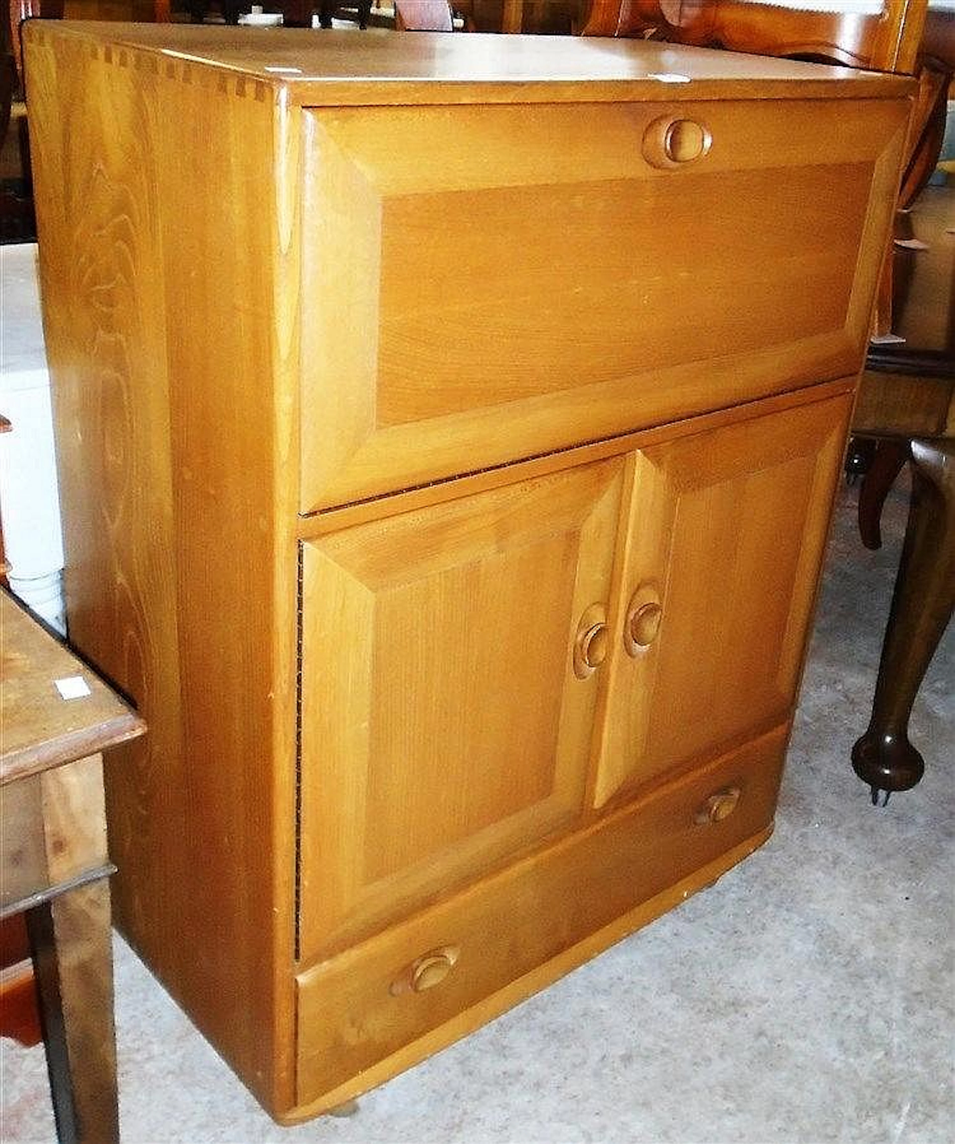 A 32½" Ercol light wood bureau with moulded fall over pair of cupboard door
